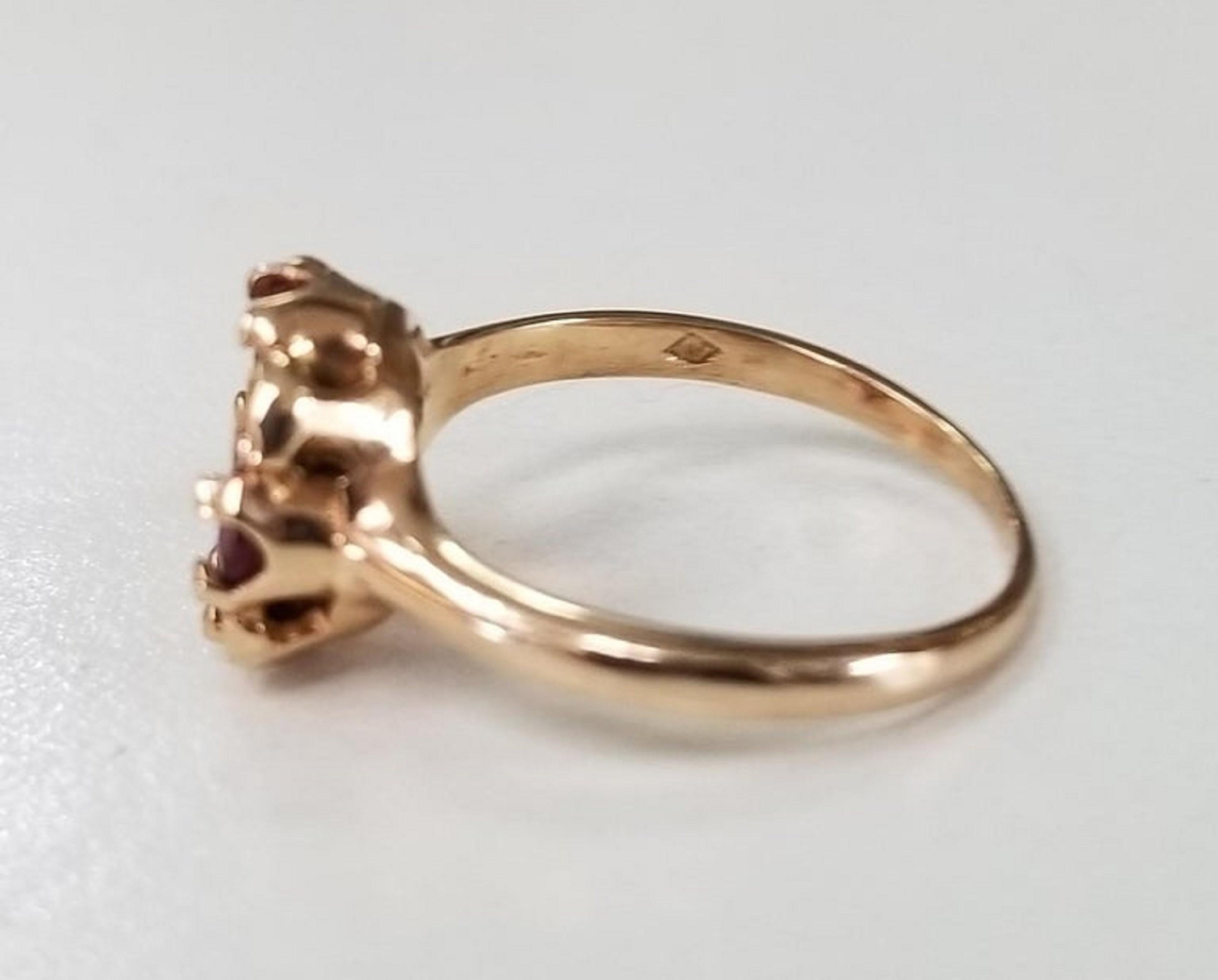 14k rose gold ruby and diamond ring, containing 4 round cut ruby of fine quality weighing .90pts. and 5 round full cut diamonds of very fine quality weighing .13pts. in an 
