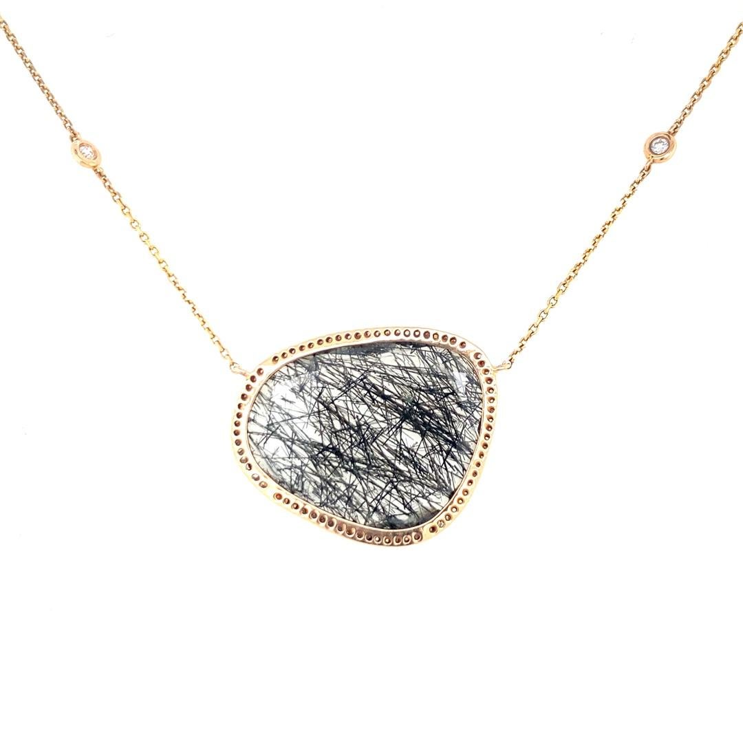 This stunning necklace features a unique rutilated quartz with a diamond halo. This necklace is 18
