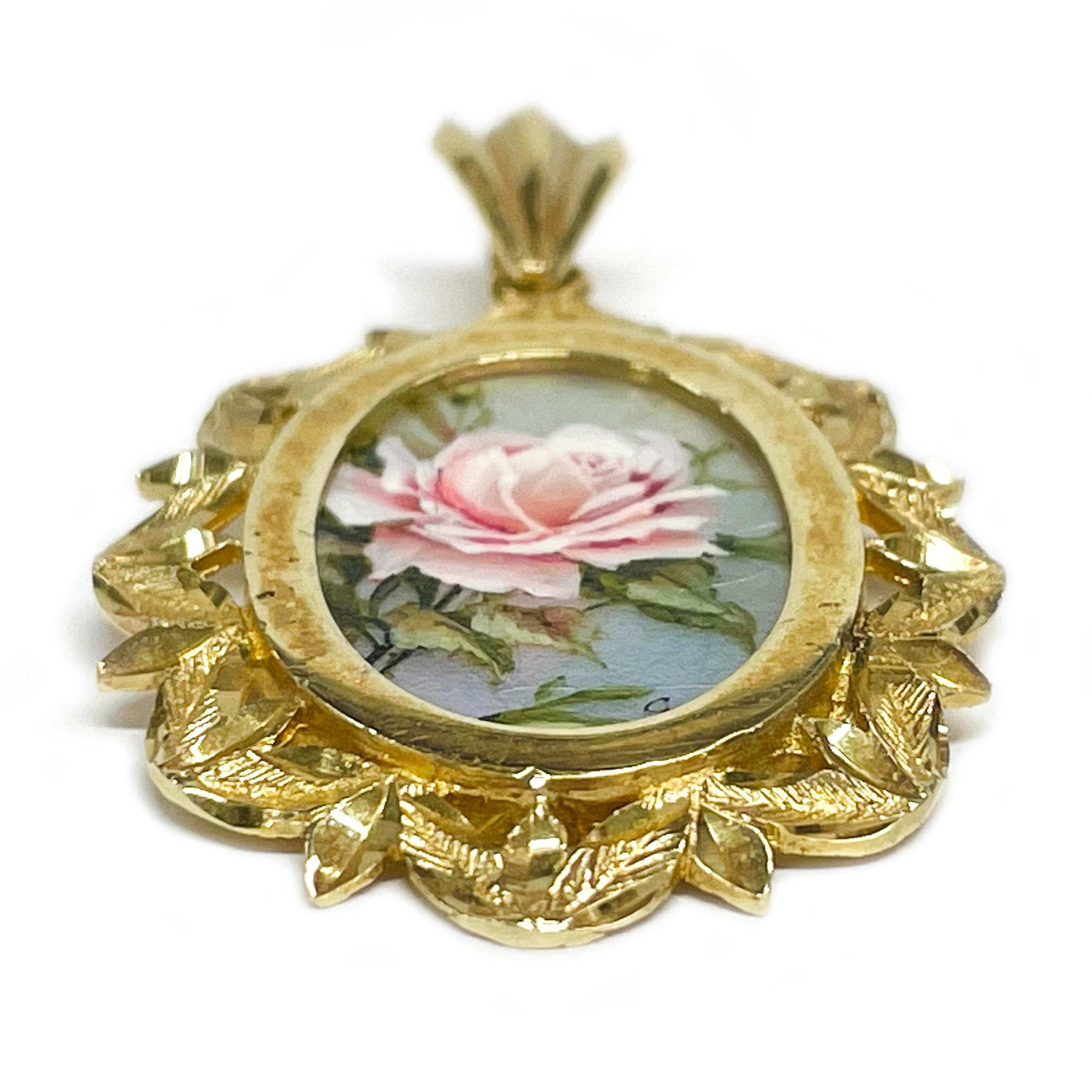 14 Karat Yellow Gold Pink Rose Hand Painted on a Mother of Pearl Pendant. The miniature painting is set in a 14 karat gold ornate oval frame with diamond-cut details. The painting is signed by the master artist, CR Charlotte. The pendant measures