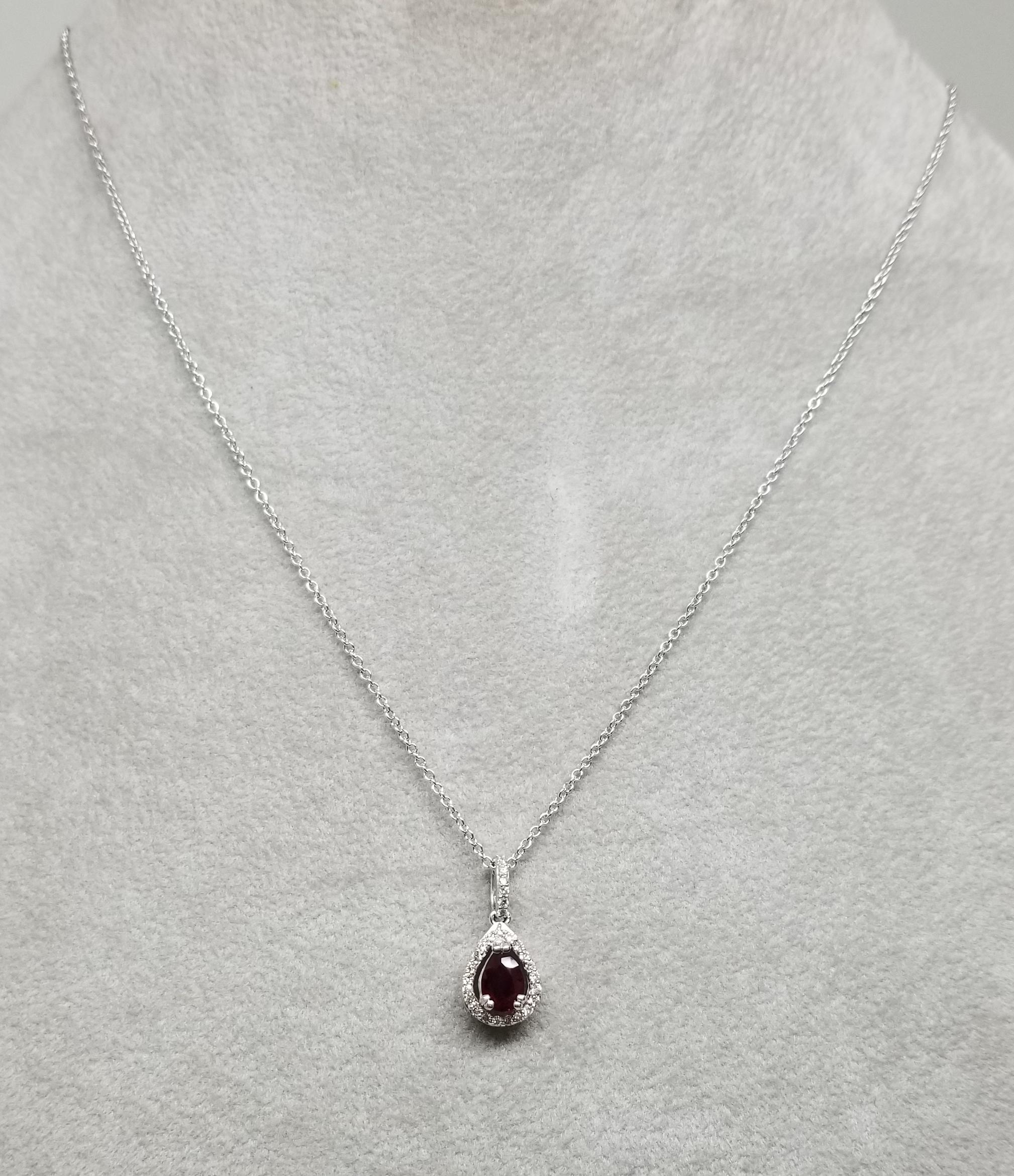 14 karat Ruby and diamond halo pendant, containing 1 pear shape ruby of gem quality weighing .65cts. and 930 round full cut diamonds of very fine quality weighing .20pts.