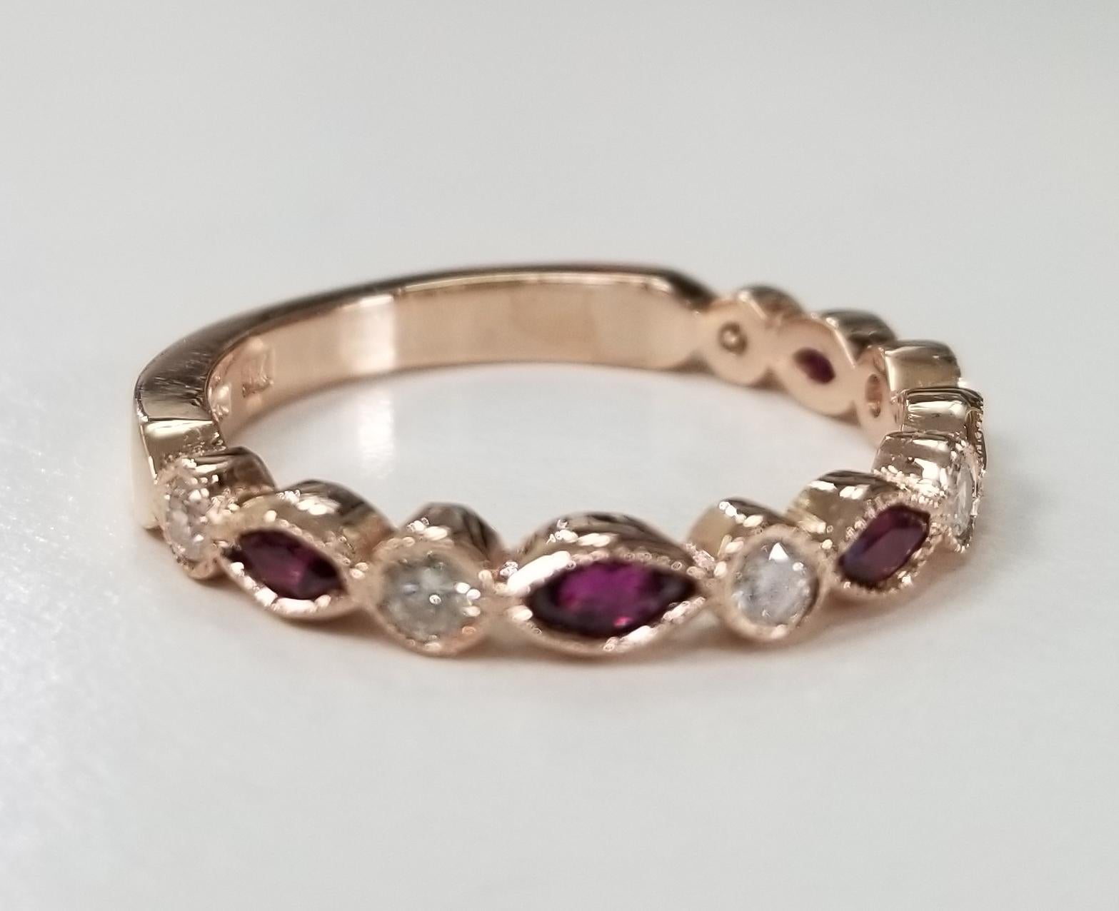14 karat ruby and diamond ring, containing 5 marquise cut rubies weighing .45pts. and 6 round full cut diamonds weighing .30pts. bezel set with milgrain.  This ring is a size 8 but we will size to fit for free.