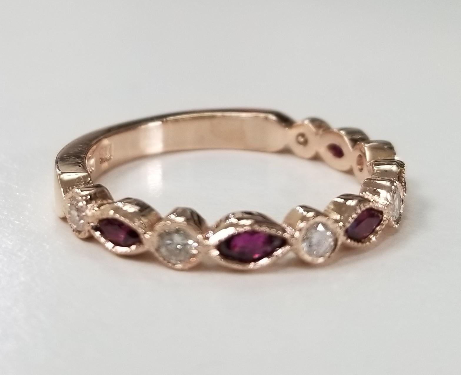 Anillo de rubíes y diamantes de 14 quilates, con 5 rubíes talla marquesa de 0,45 pts. y 6 diamantes redondos talla plena de 0,30 pts. engastados en bisel con milgrain.  Este anillo es de la talla 8, pero te lo ajustamos gratis.