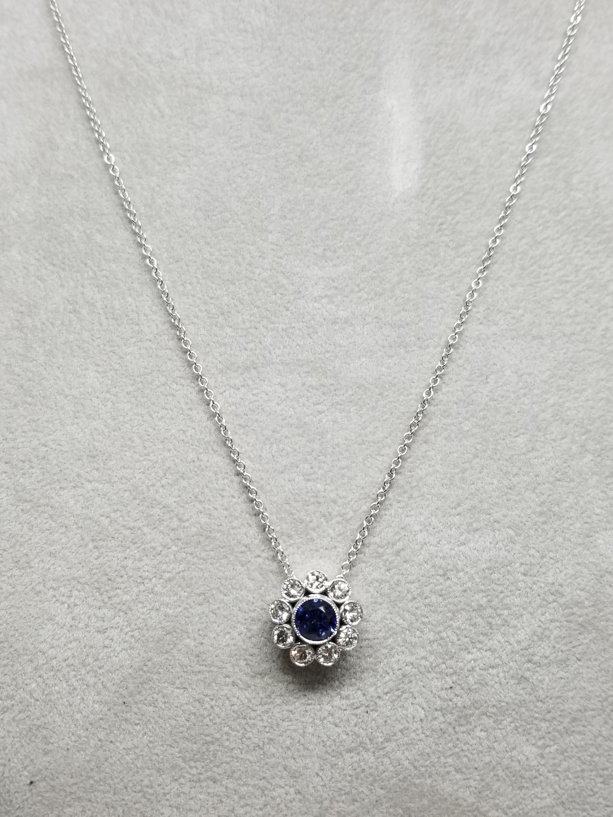 14 karat Sapphire and diamond halo pendant, containing 1 round blue sapphire of gem quality weighing 1.11cts. and 9 round full cut diamonds of very fine quality weighing .80pts.