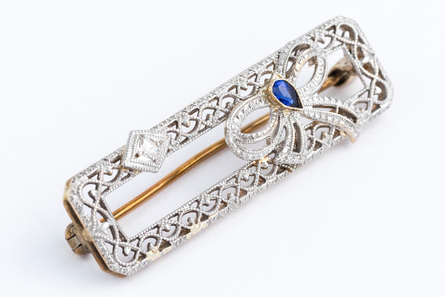 Circa 1920s 14 karat diamond and sapphire pin. This pin features 14 karat yellow gold bottom with a white rhodiwined top.* It has one small pear shaped sapphire and one small diamond with latticework detail. Total weight 3.50 grams.
