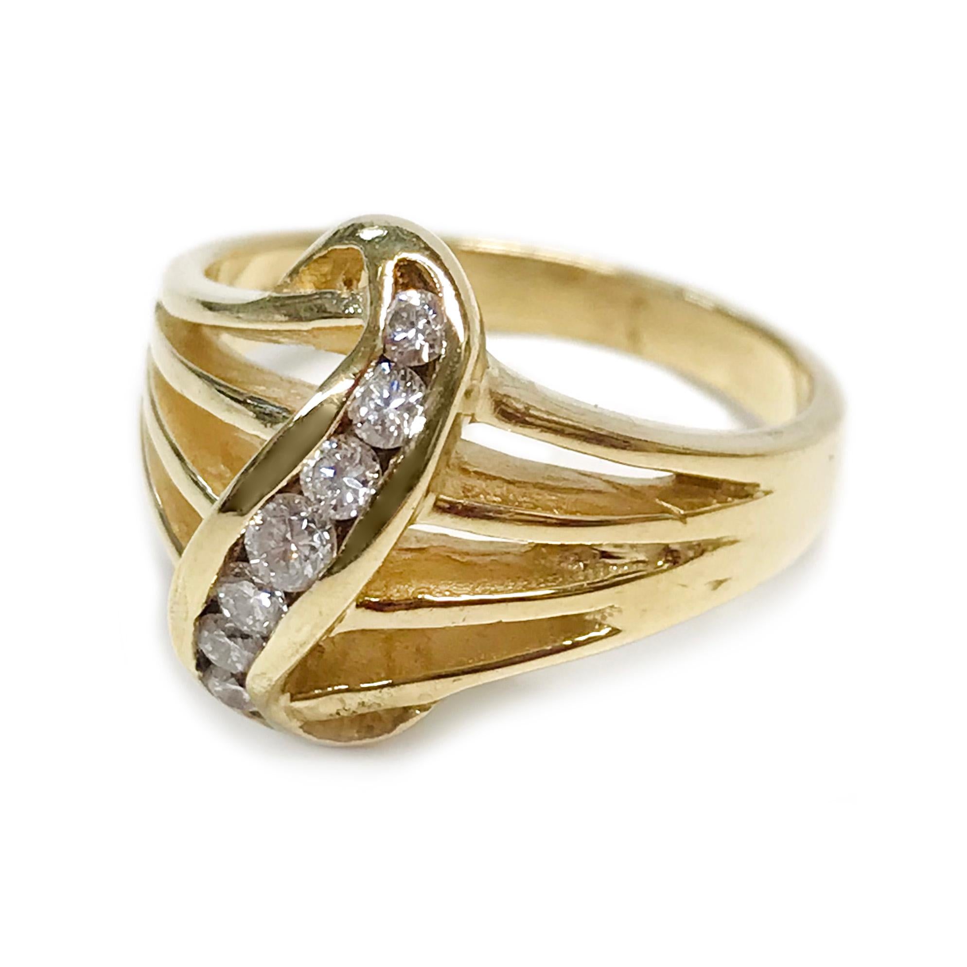 Anello a sette diamanti da 14 carati. L'anello a fascia multi-split presenta sette diamanti rotondi incastonati a canale e incastonati verticalmente al centro in una curva d'oro. I diamanti hanno dimensioni comprese tra 2,0 e 2,5 mm. I sette