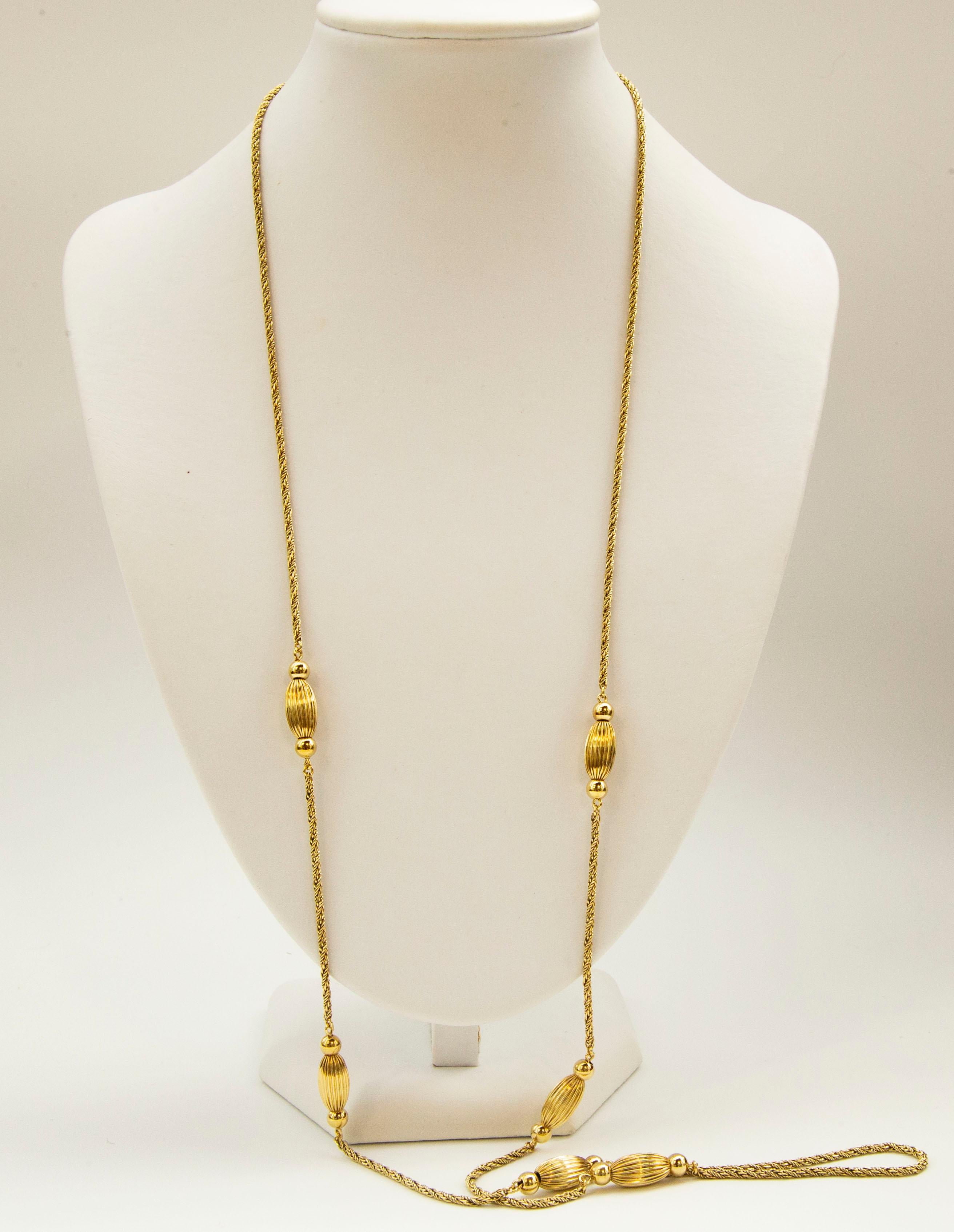 Un collier vintage en or jaune massif 14 carats avec des sphères nervurées et des boules de forme ovale. Le collier est composé d'une double chaîne en corde et se ferme à l'aide d'un fermoir à anneau à ressort.  
Le collier a une apparence élégante