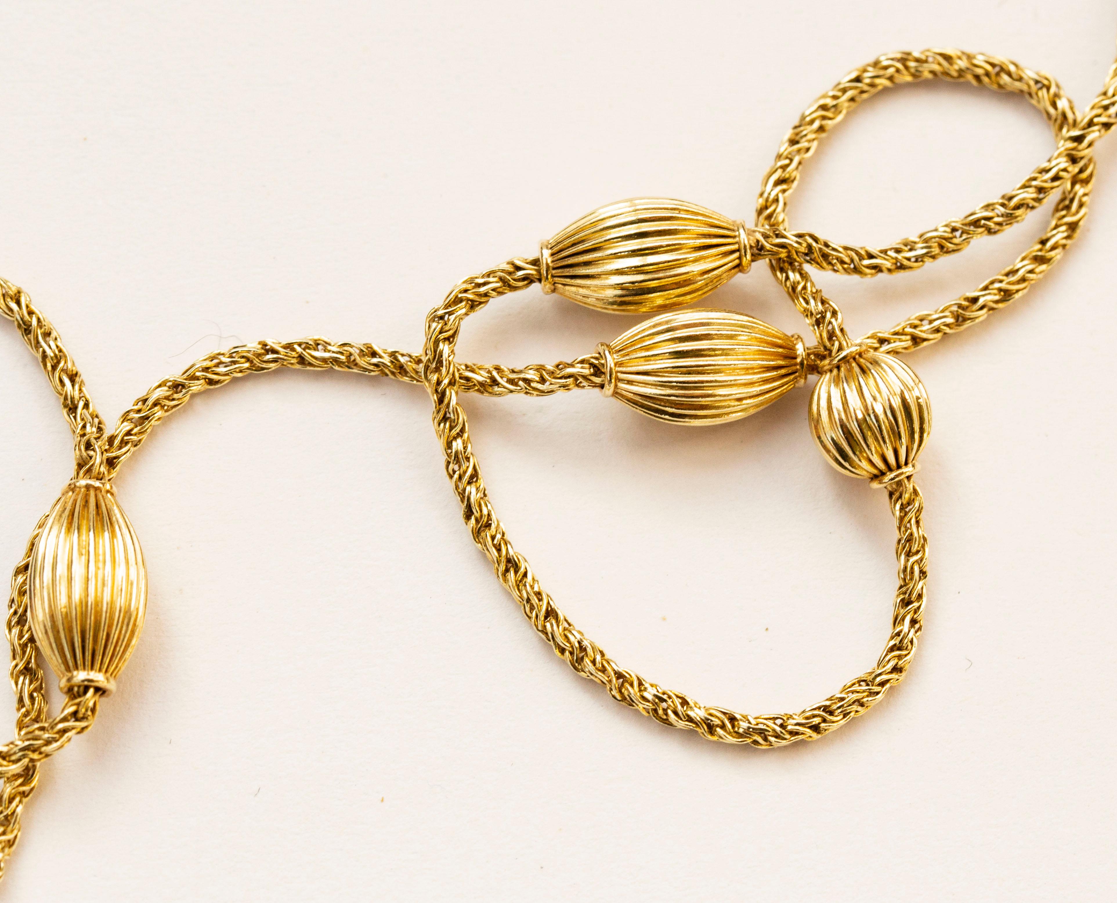 A vintage 14 karat solid yellow gold necklace with ribbed spheres and oval shaped balls. The necklace features a double rope chain and it closes with a spring ring clasp. The necklace has an elegant appearance and it would be a great addition to any