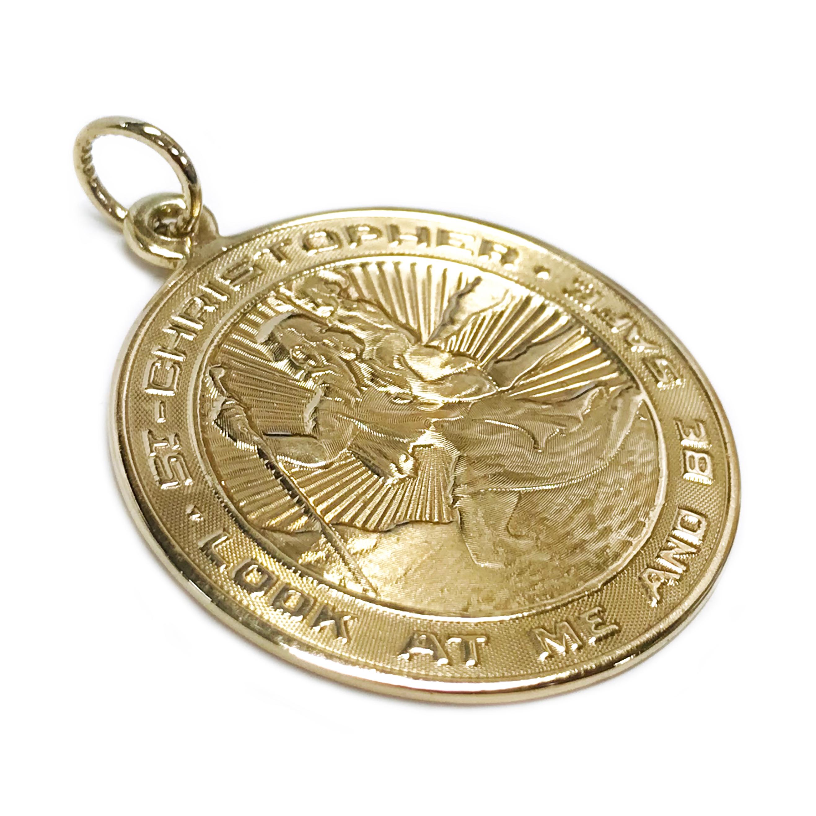 14 Karat St. Christopher Medallion Pendant. The pendant measures 30.0mm in diameter. The front of the pendant features Saint Christopher and the words 