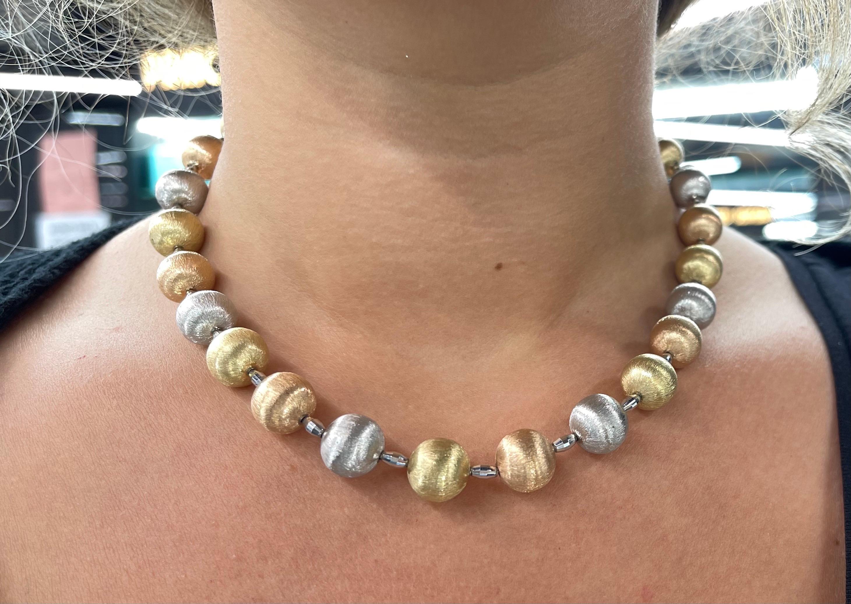 Collana in oro 14 carati con 24 sfere d'oro tricolore con finitura spazzolata del peso di 40 grammi. 
Ogni pallina misura 12 MM