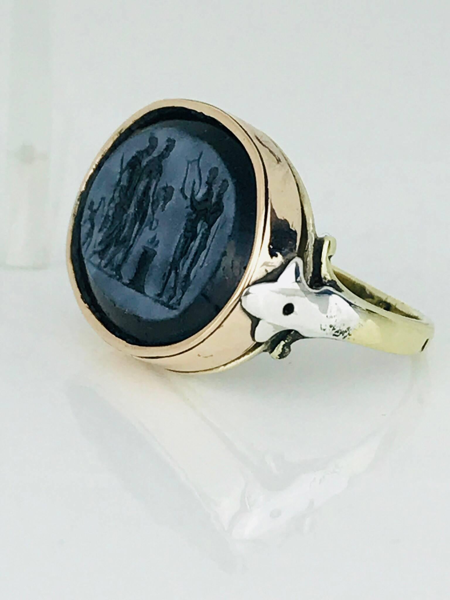 14 carat yellow, white and rose gold ring features a bezel-set black onyx stone, intaglio engraved with a scene from mythology, hand made assembly shows this vintage ring Circa 1935

Face of ring measures 20.90 mm long x 15.75 mm wide x 4.75 mm
