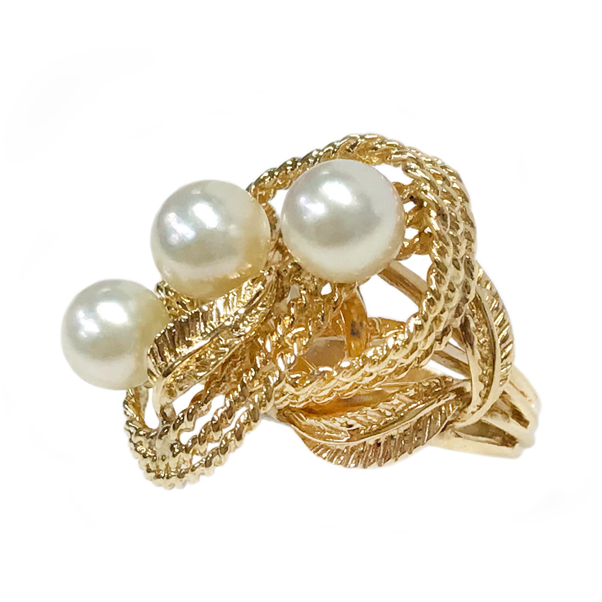 14 Karat Twisted Wire Three Pearl Ring. This statement ring features free form twisted gold rope looped and intertwining with three cultured pearls. There are five gold leaves in total, two near the split shack, and one at the center that