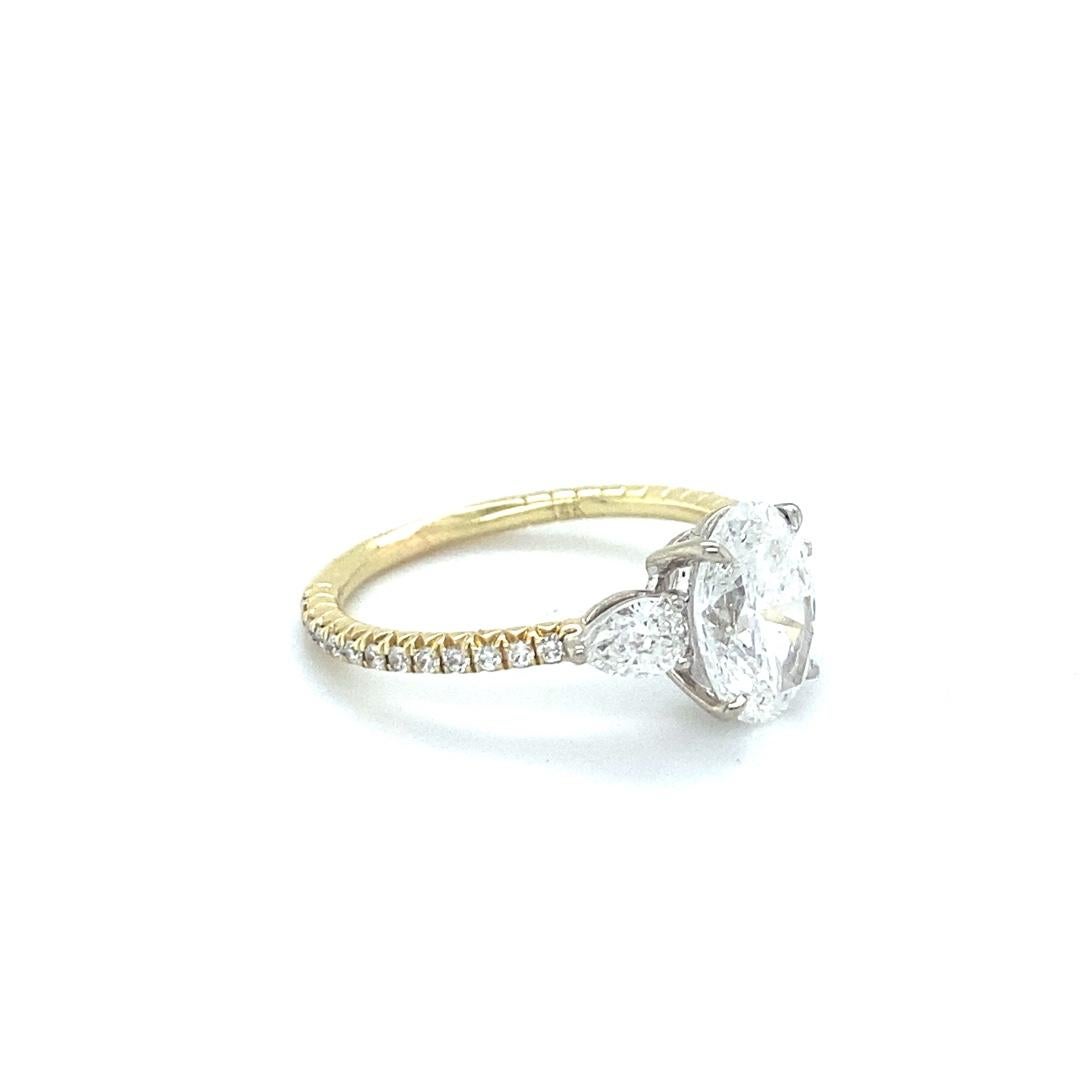Dieser wunderschöne zweifarbige Verlobungsring repräsentiert mit seinem klassischen Drei-Stein-Design die Vergangenheit, Gegenwart und Zukunft. Dieser Ring ist mit einem atemberaubenden ovalen Diamanten von 1,70 Okt. ausgestattet, der die Farbe F