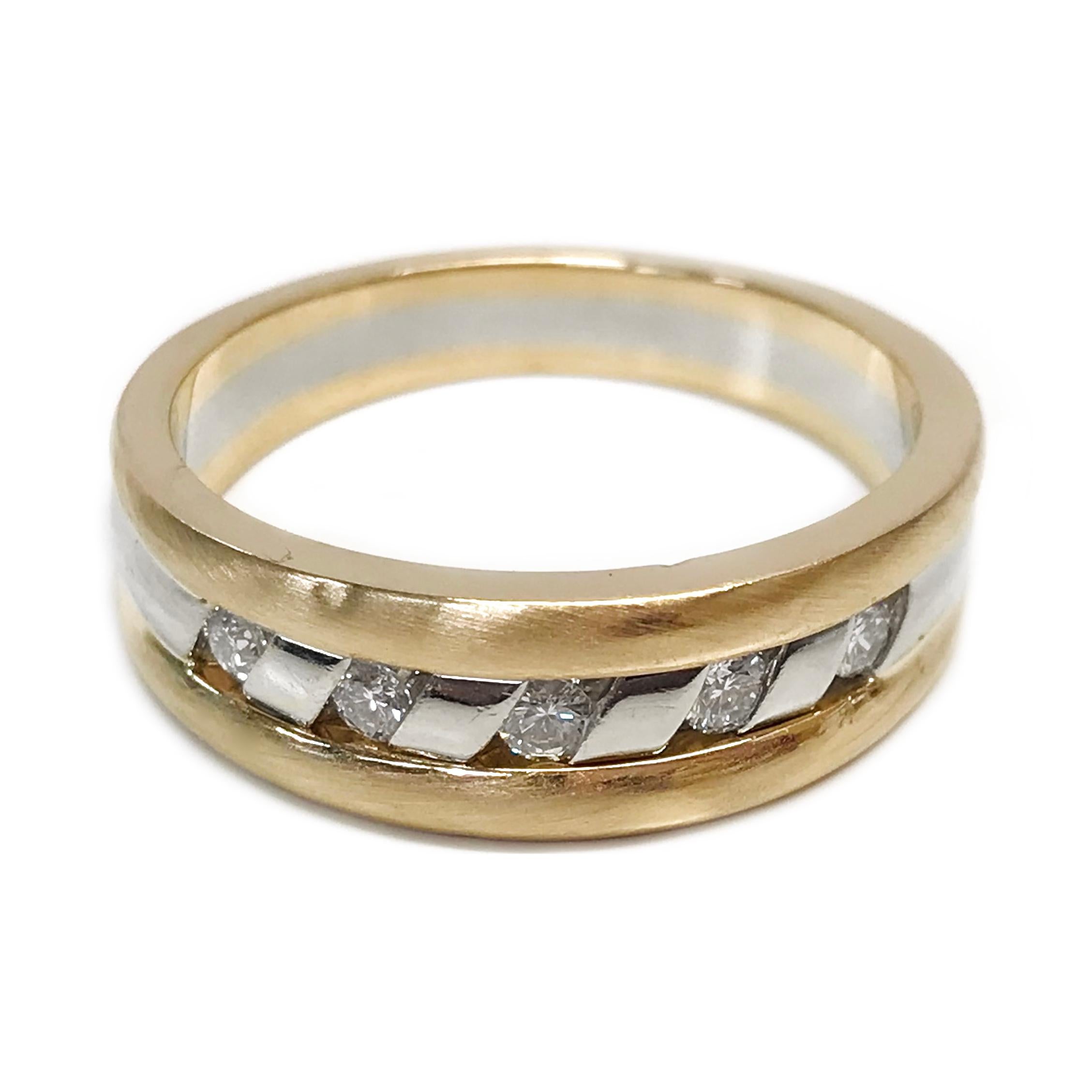14 Karat Two-Tone Channel Set Diamond Ring. The band ring features five round diamonds channel-set in diagonal slots. There are yellow gold satin finish bands on the outer edges and a single shiny smooth finish band in white gold. The 2.5mm diamonds