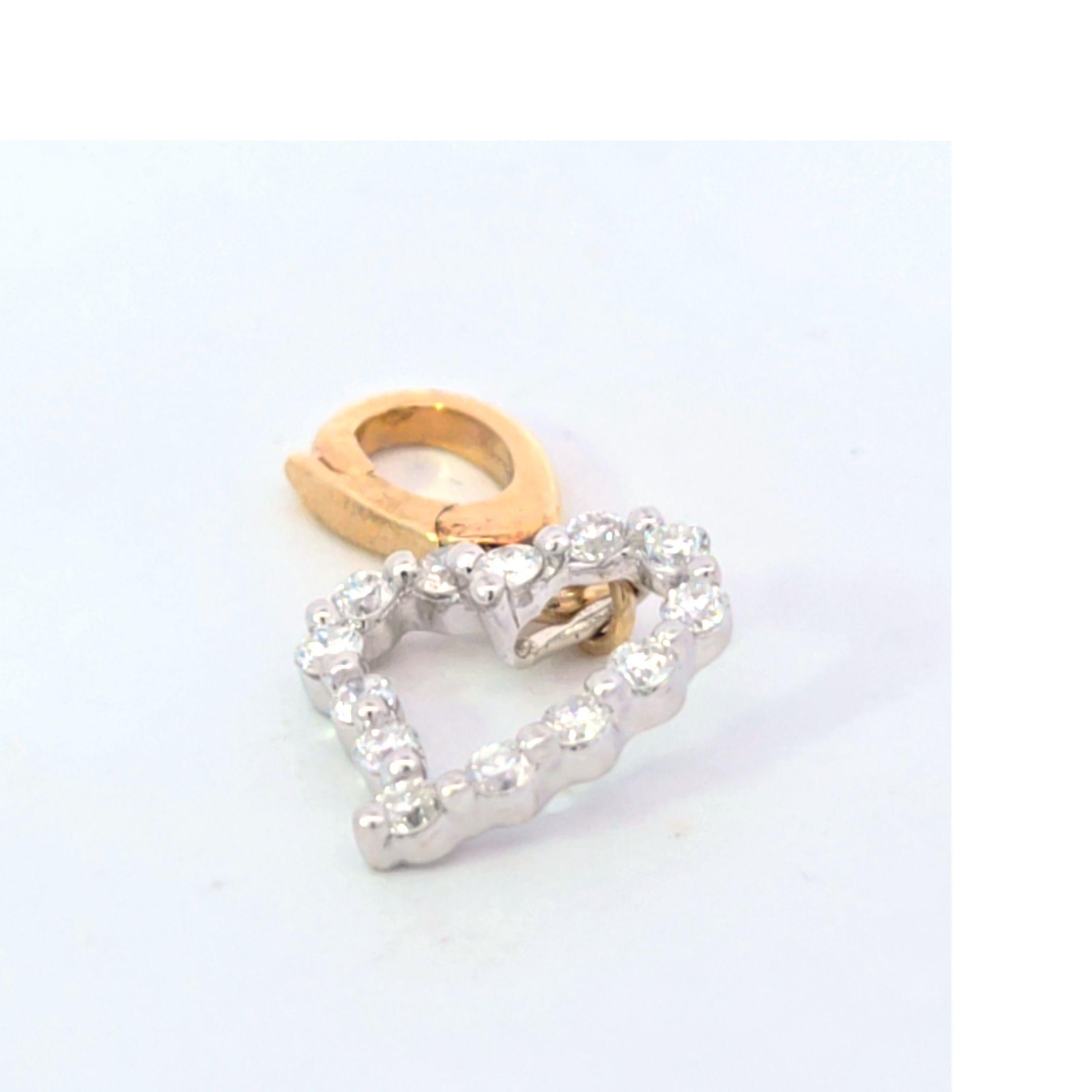 This lovely diamond heart charm is in 14 karat yellow and white gold. 