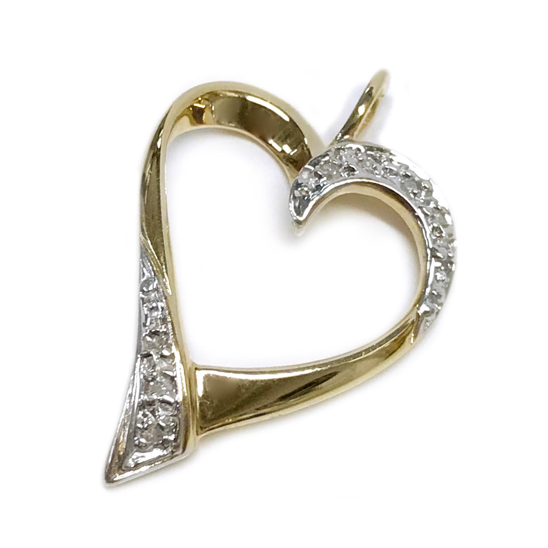 14 Karat Two-Tone White and Yellow Gold Diamond Heart Pendant. Four round diamonds are bead set in white gold on the top curve of one side and four on the opposite lower side of the pendant. The eight diamonds measure 1.2mm and have a total carat