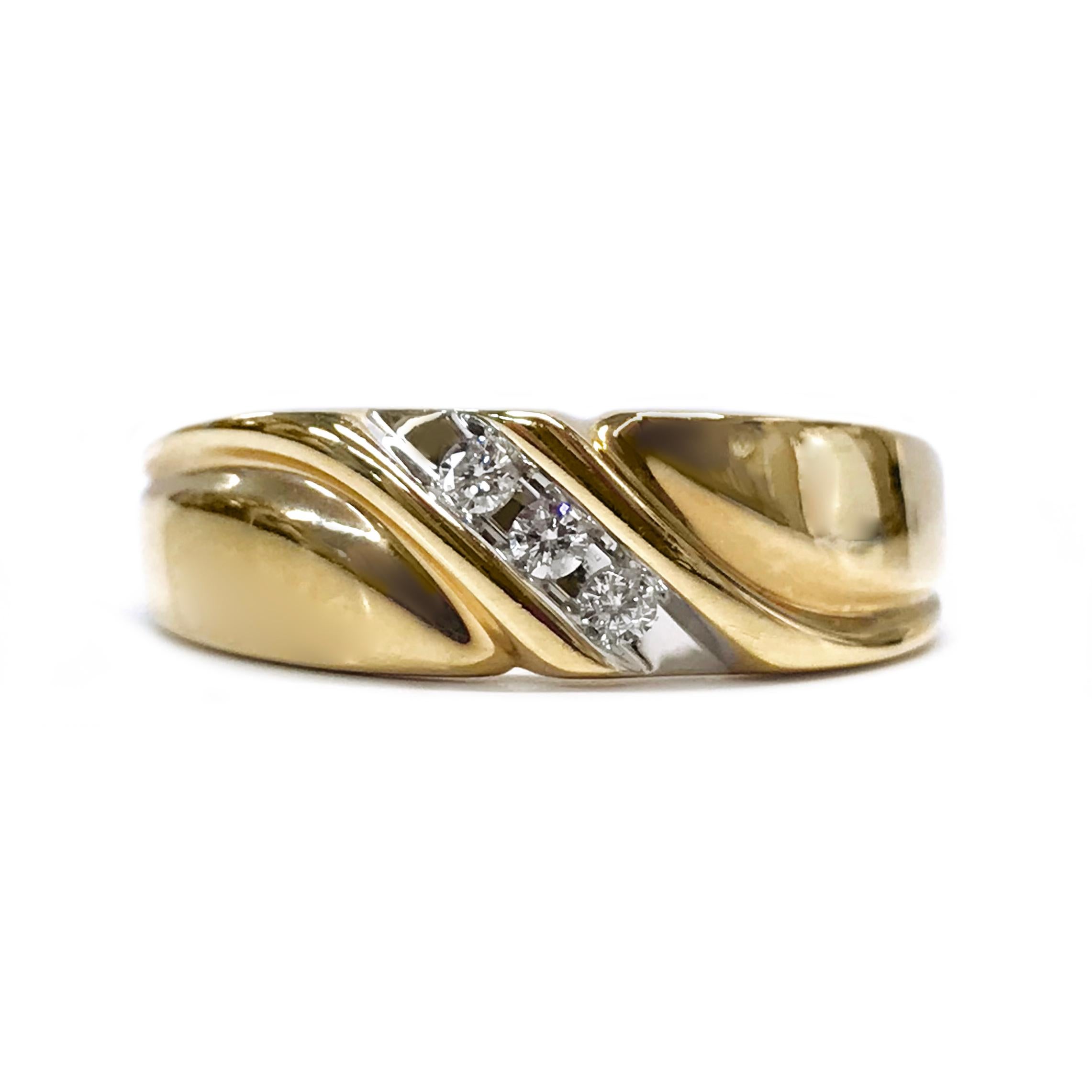 14 Karat Two-Tone Three Diamond ring. The ring features a yellow gold band with curves that meet at the center, at the center are three round channel-set diamonds set in white gold. The diamonds have a total carat weight of 0.75ctw. Stamped on the