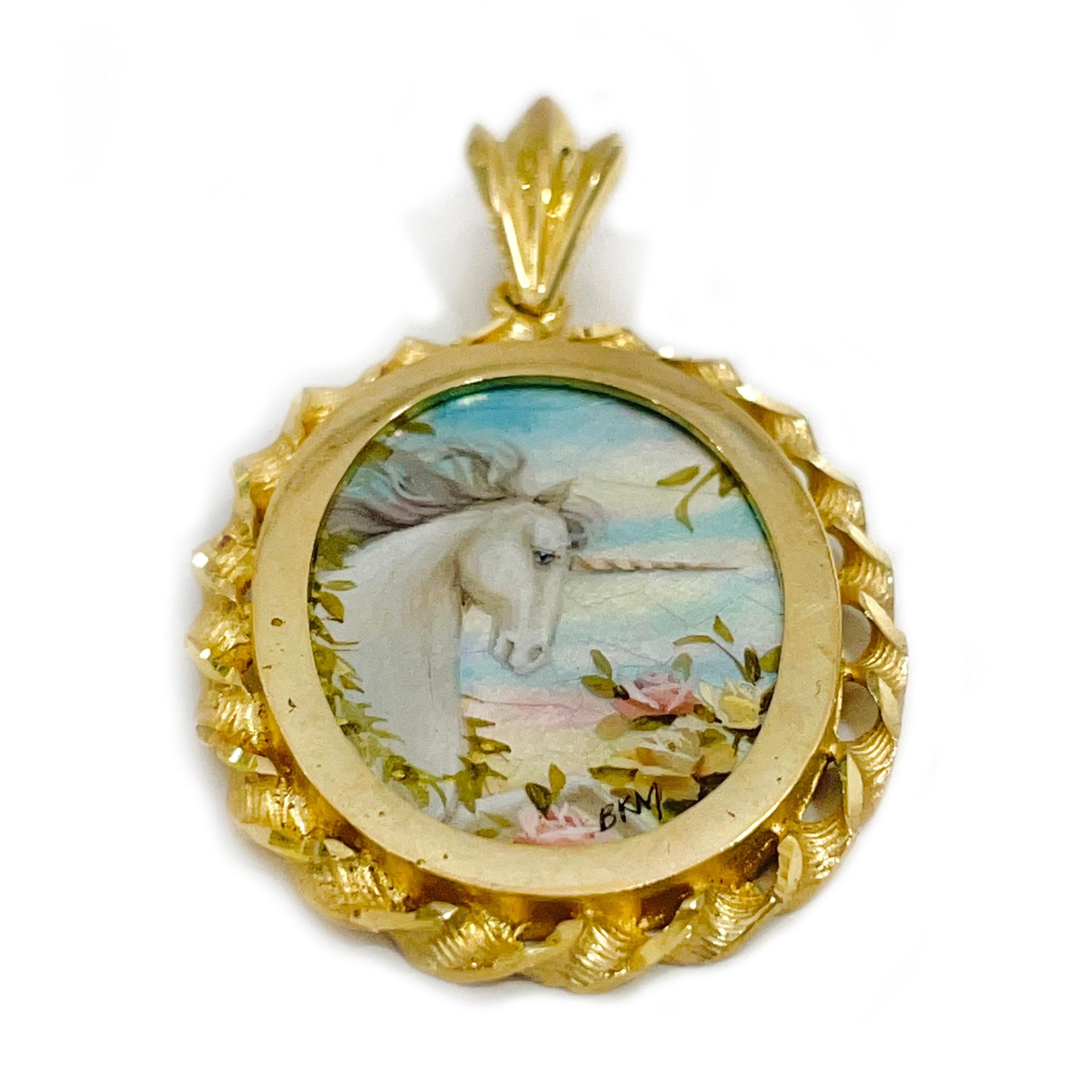 14 Karat Yellow Gold Forest Unicorn Hand Painted on a Mother of Pearl Pendant. The miniature painting is set in a 14 karat gold twisted rope oval frame with diamond-cut details. The painting is signed by the master artist, BKM Brian M. and includes