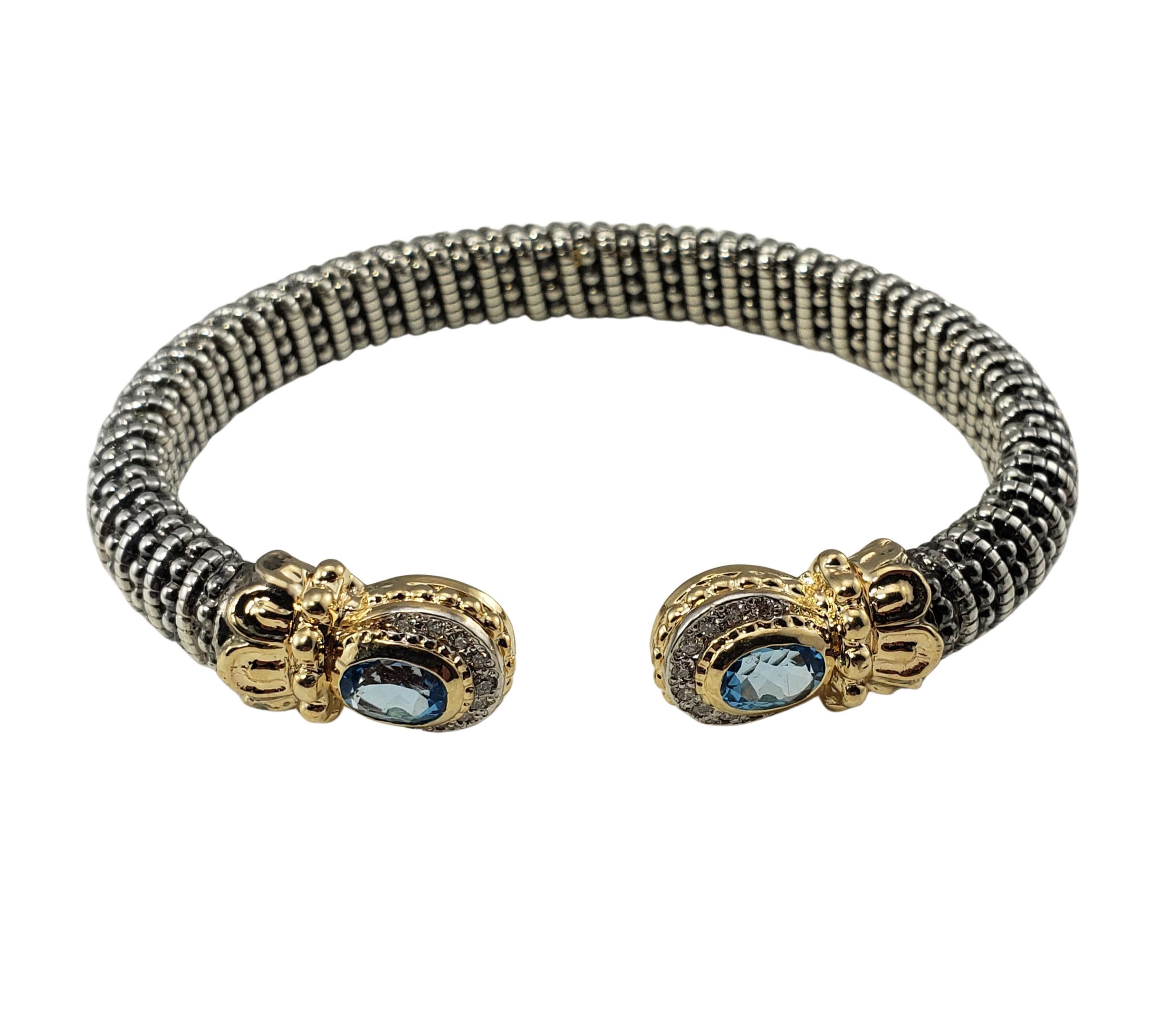 Vahan Sterling Silver/14 Karat Yellow Gold Blue Topaz and Diamond Bracelet-

This stunning open bracelet features two oval blue topaz gemstones (7 mm x 5 mm) and 18 round brilliant cut diamonds set in beautifully detailed sterling silver and 14K