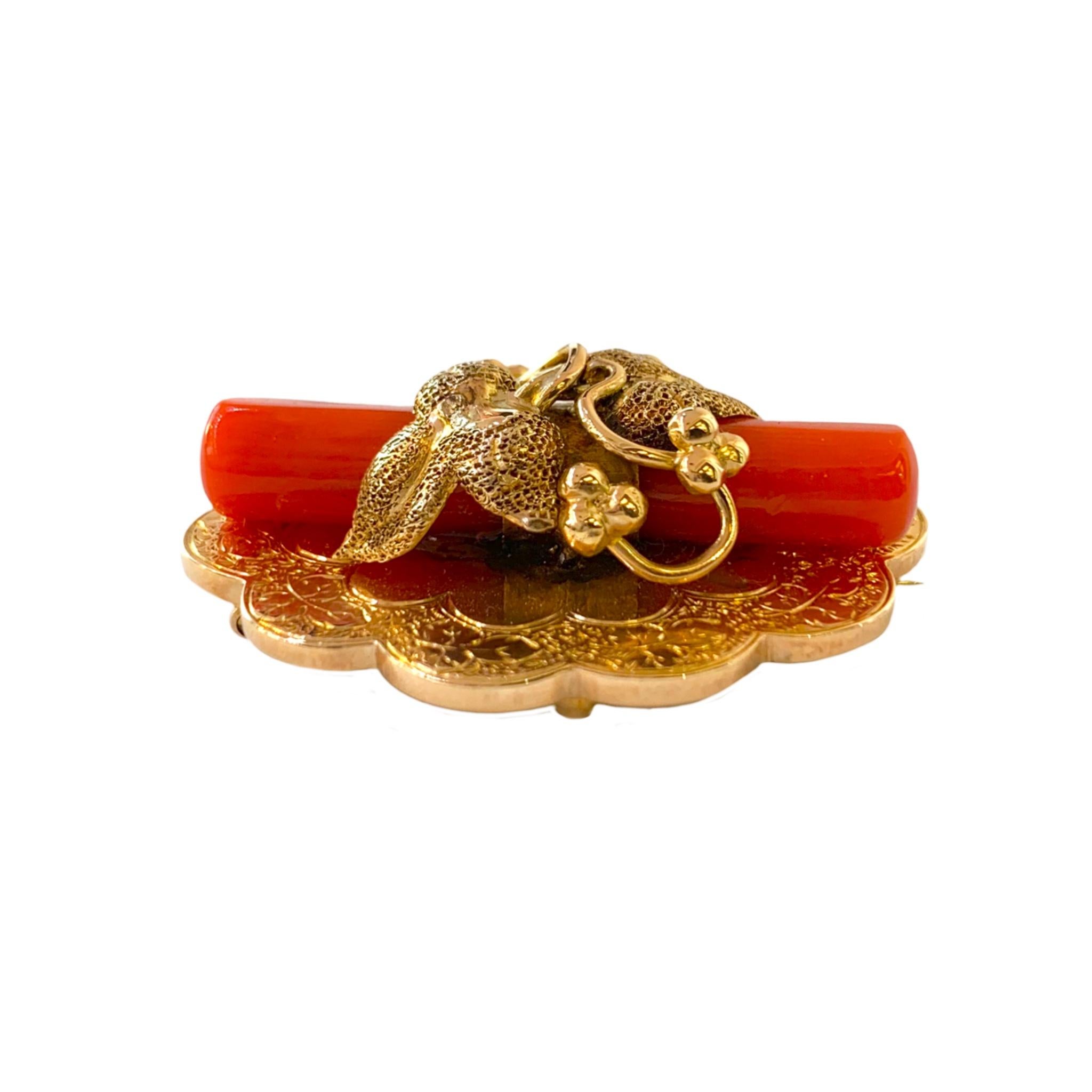 This beautiful Victorian cylindrical orange coral is nestled in the 14 karat yellow gold vintage floral design that can be worn as a pendant or brooch.