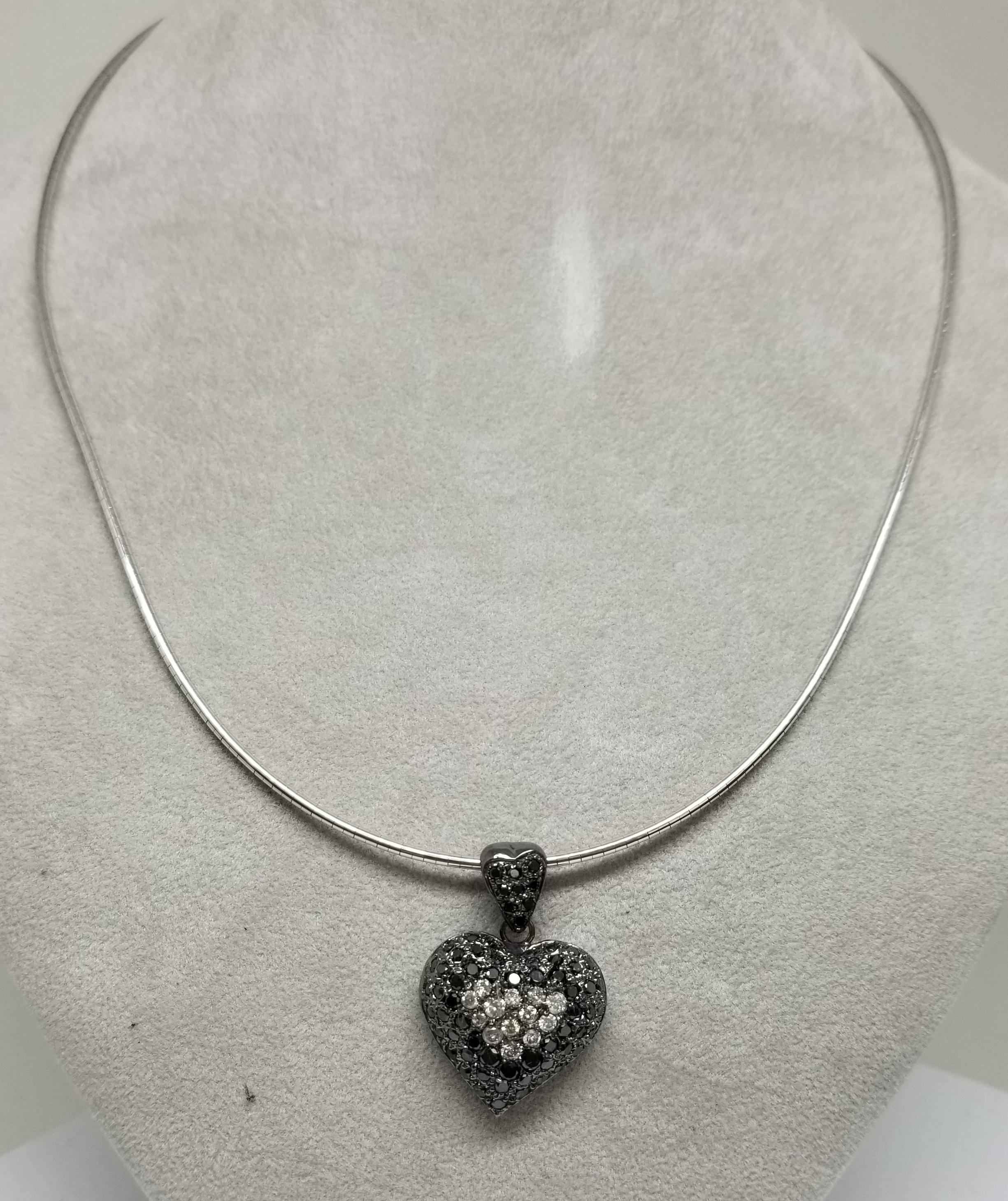 14 karat White and Black Diamond Heart pendant, containing 23 round full cut diamonds weighing .70pts. and 67 round full cut black diamonds weighing 2.30cts.  with a black antiquing on a 18 inch chain.