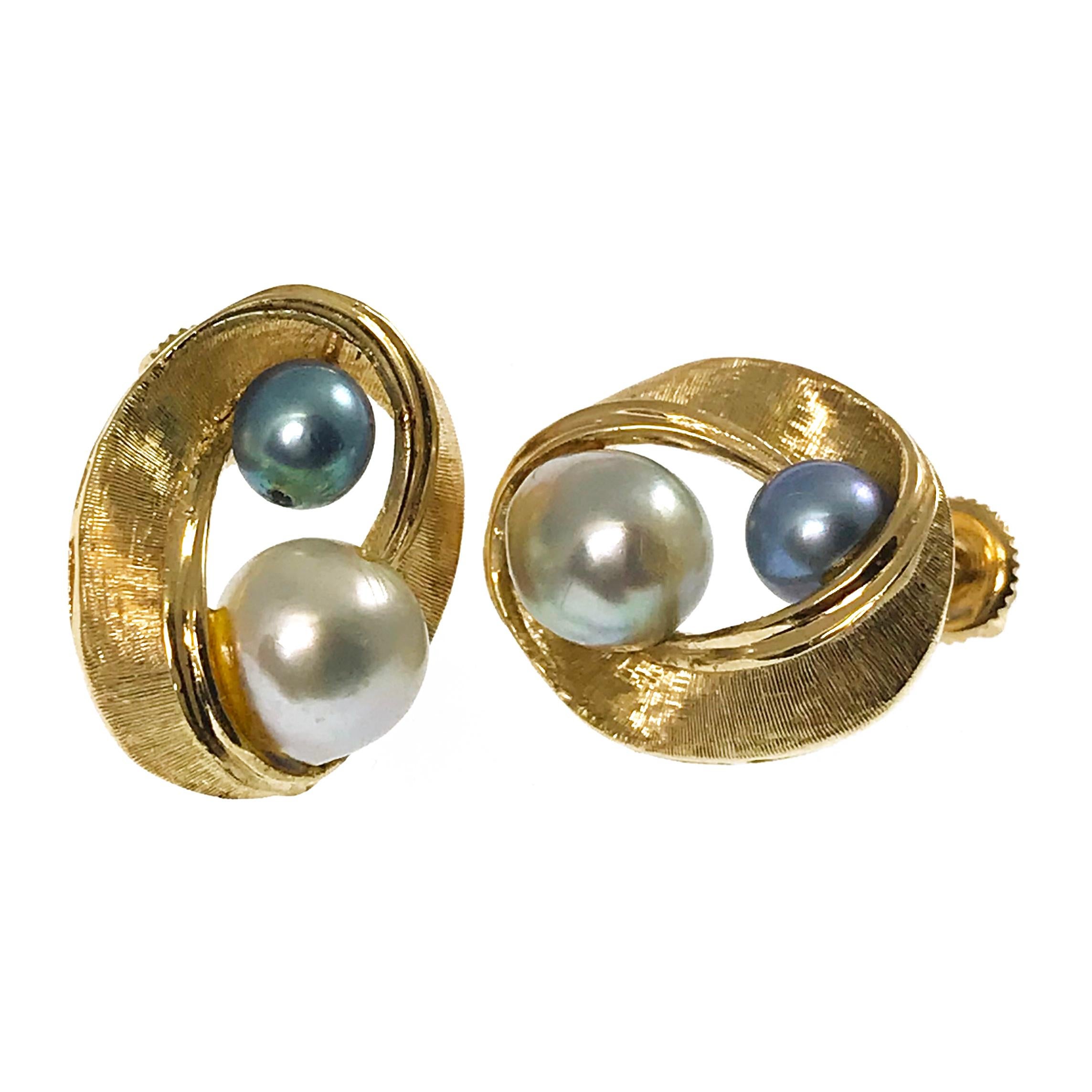 boucles d'oreilles tourbillon de perles blanches et bleu-gris 14 carats. Ces boucles d'oreilles comportent deux perles bleu-gris (entièrement percées) et un ruban tourbillonnant doré texturé. Les perles sont serties sur le haut et le bas de la