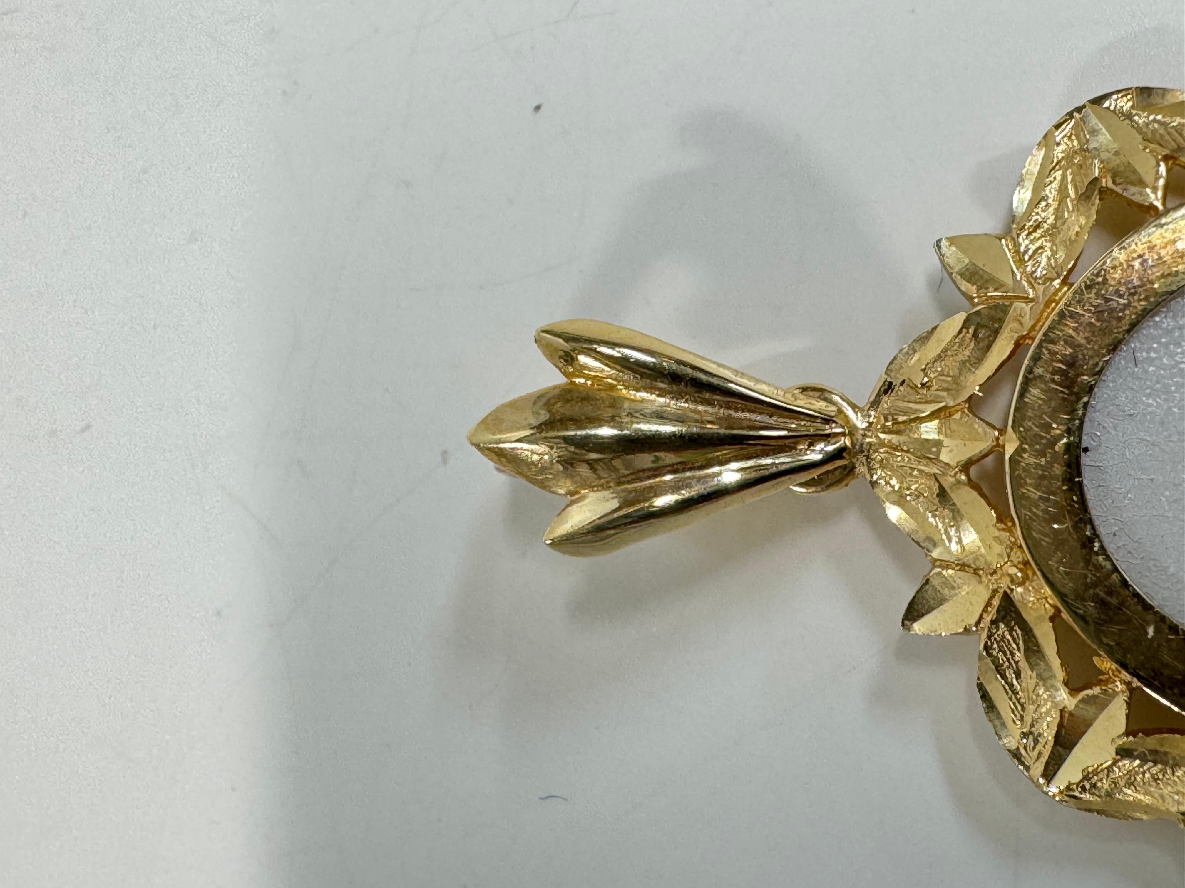 Farfalle e rose in oro giallo 14 carati dipinte a mano su un ciondolo in madreperla. Il dipinto in miniatura è incastonato in una cornice ovale ornata in oro 14 carati con dettagli tagliati a diamante. Il dipinto è firmato dall'artista, BKM Brian M.