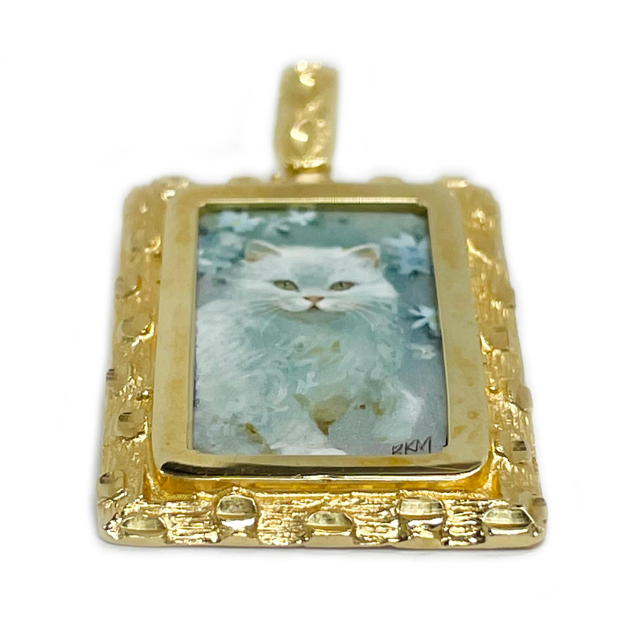 14 Karat Yellow Gold White Cat Hand Painted on Mother of Pearl Pendant. The miniature painting is set in a 14 karat gold rectangular frame with diamond-cut details. The painting is signed by the master artist,  BKM Brian M. and includes a