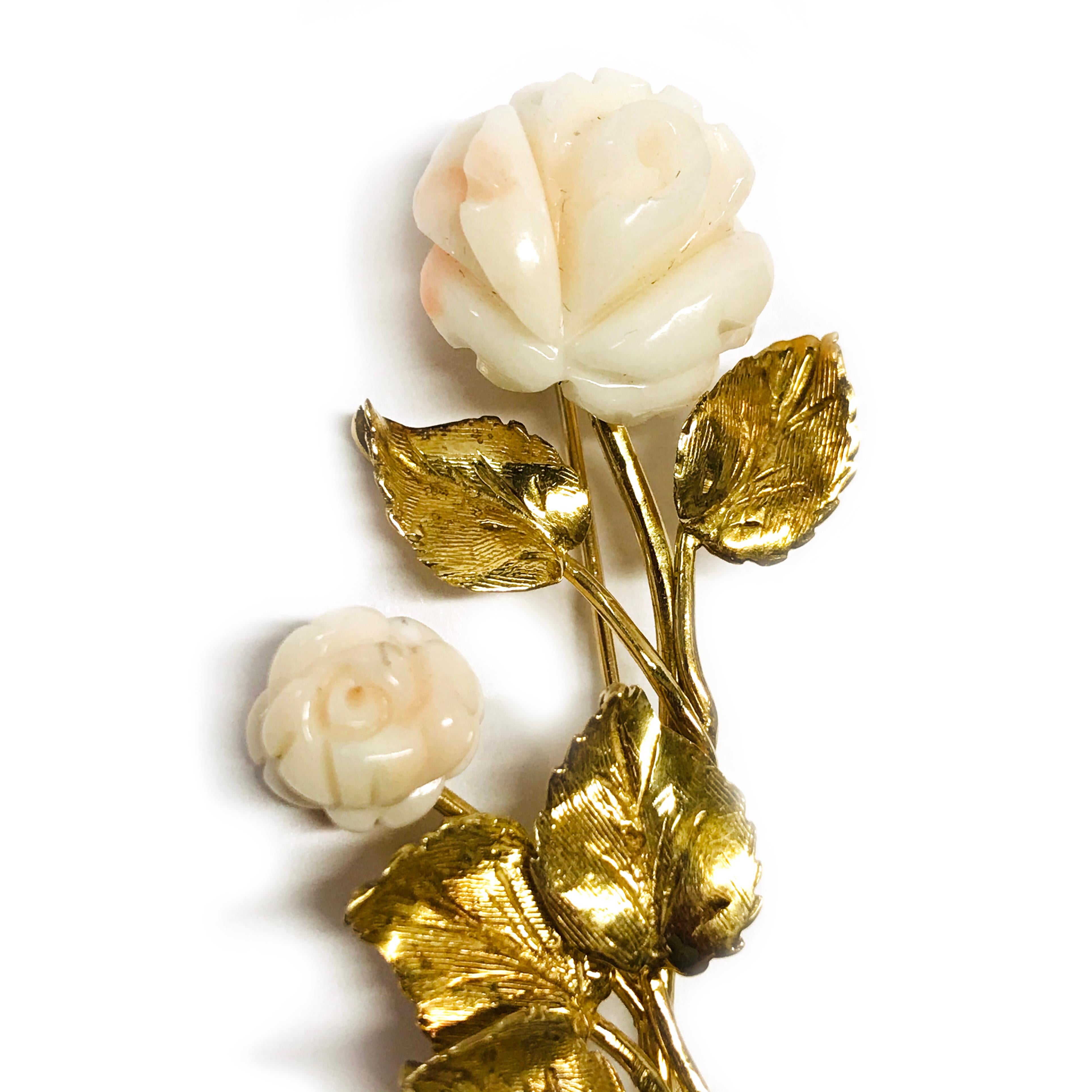 14 Karat Angel Skin Coral Flower Brooch. This brooch features two angel skin Coral flowers and five leaves with smooth and florentine finishes. The coral is mostly white with a whisper of orange-pink. The coral flowers are The brooch/pin has a gold
