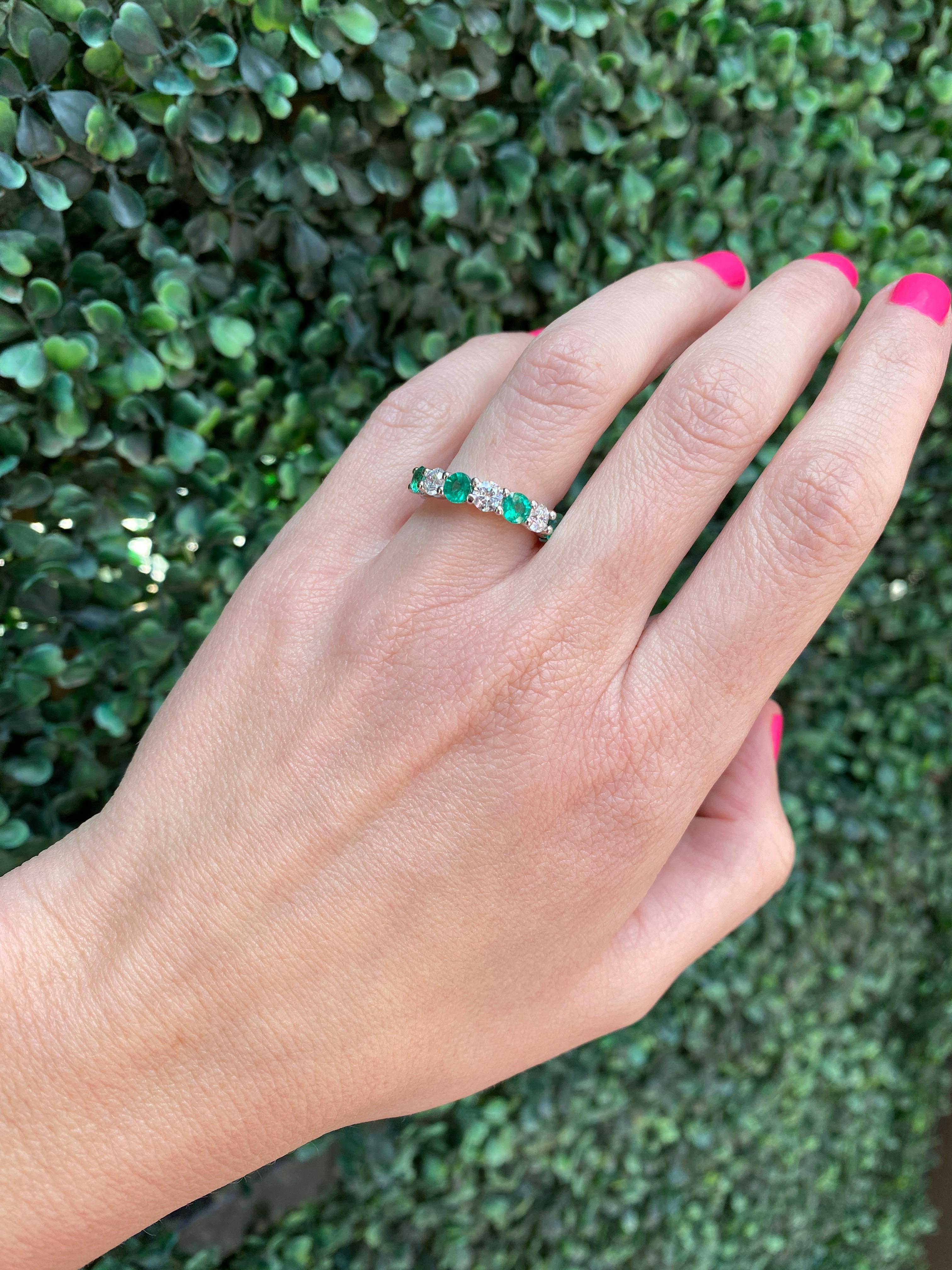 This 14 karat white gold band features 0.92 carat total weight in round emeralds alternating with 0.75 carat total weight in round diamonds set in 14 karat white gold. Wear alone or layer with your other favorite rings for your own unique look. It