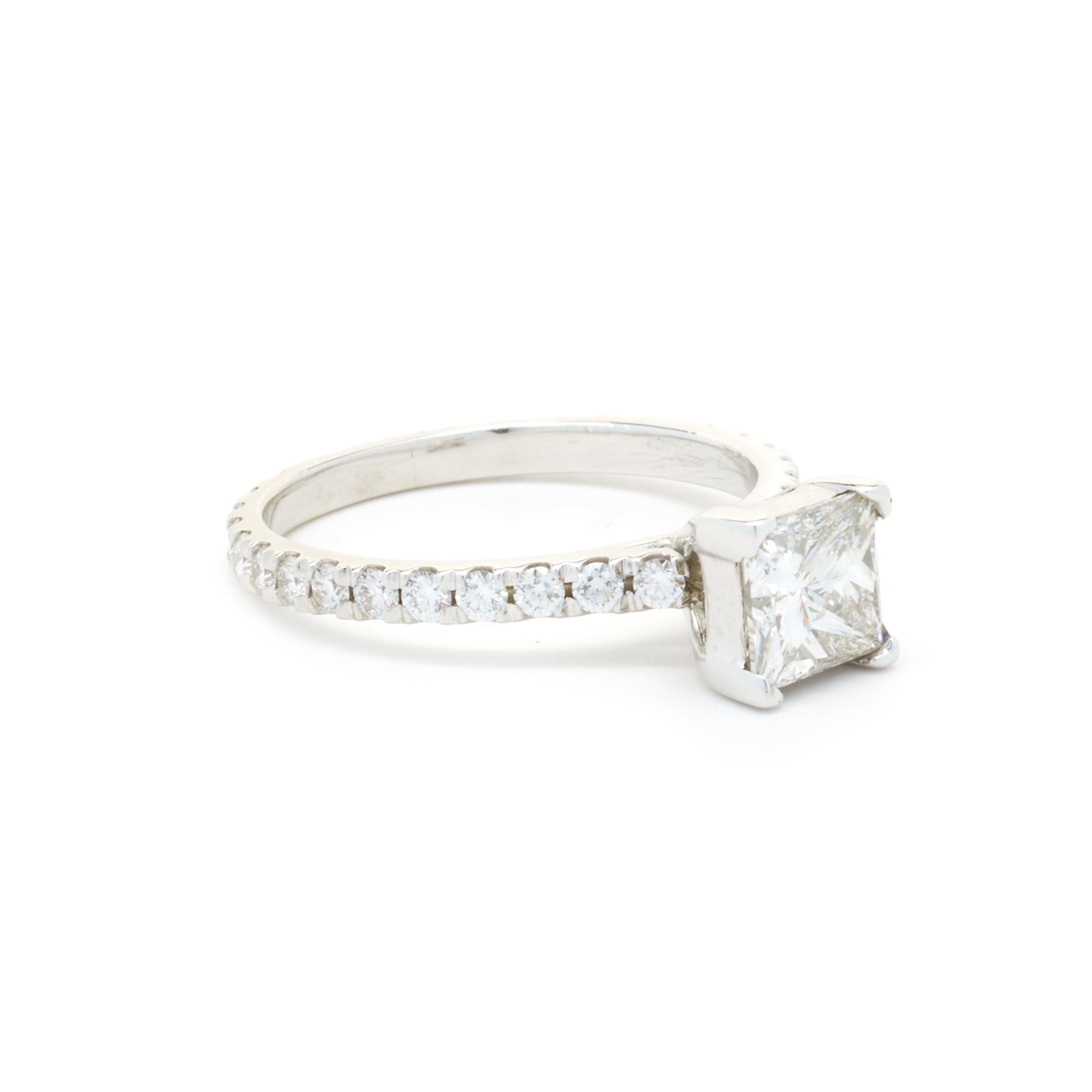 Designer: custom
Material: 14K white gold
Diamond: 1 princess cut = 1.25ct 
Color: H
Clarity: SI2
Diamond: 28 round cut = .70cttw
Color: G
Clarity: SI1
Ring Size: 7 (please allow up to 2 additional business days for sizing requests)
Dimensions: ring