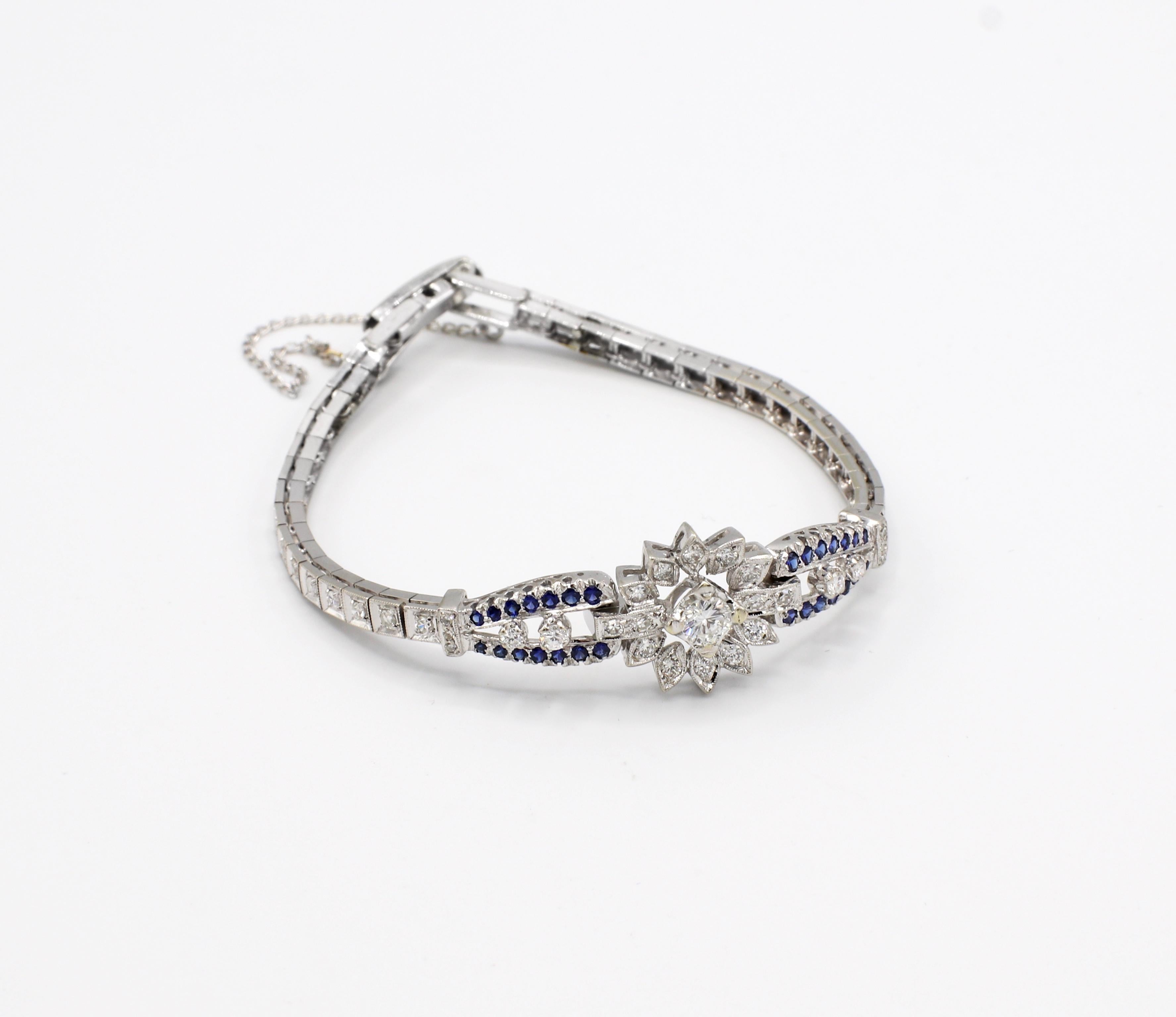 Vintage 14 Karat White Gold 1.50 Carat Diamond & Blue Sapphire Bracelet 

Metal: 14k white gold
Weight: 11.78 grams
Diamonds: Approx. 1.50 carats G VS, center diamond is approx. .30 carats 
Length: 6.75 inches 
Width: 5.2mm- 3.3mm 
Safety chain 
