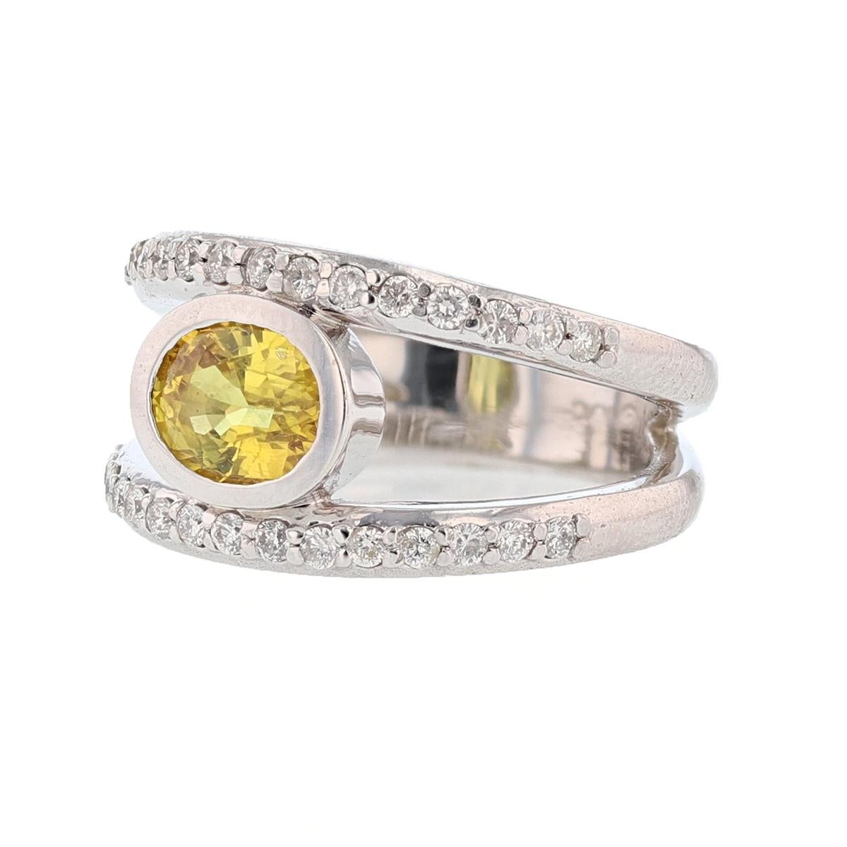 This ring is set in 14 karat white gold. The center stone is a Oval Yellow Sapphire weighing 1.79 carats and is bezel set. The mounting features 30 round cut  diamonds weighing 0.46cts with a color of (H/I) and a clarity of (SI2-I1).