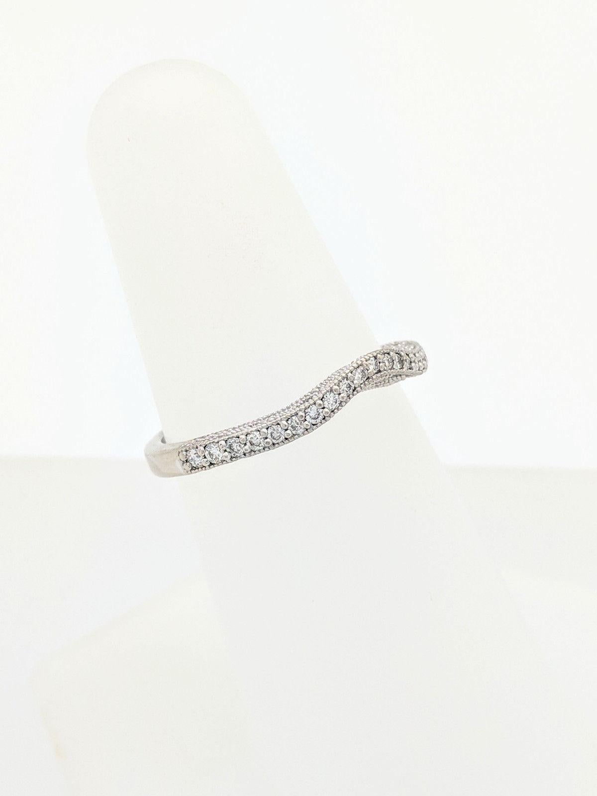 You are viewing a Beautiful Pave Diamond Curved Wedding Band. This band is crafted from 14k white gold and weigh 2.6 grams. This ring features (21) natural round brilliant cut diamonds that are individually prong set for a total carat weight of 0.21