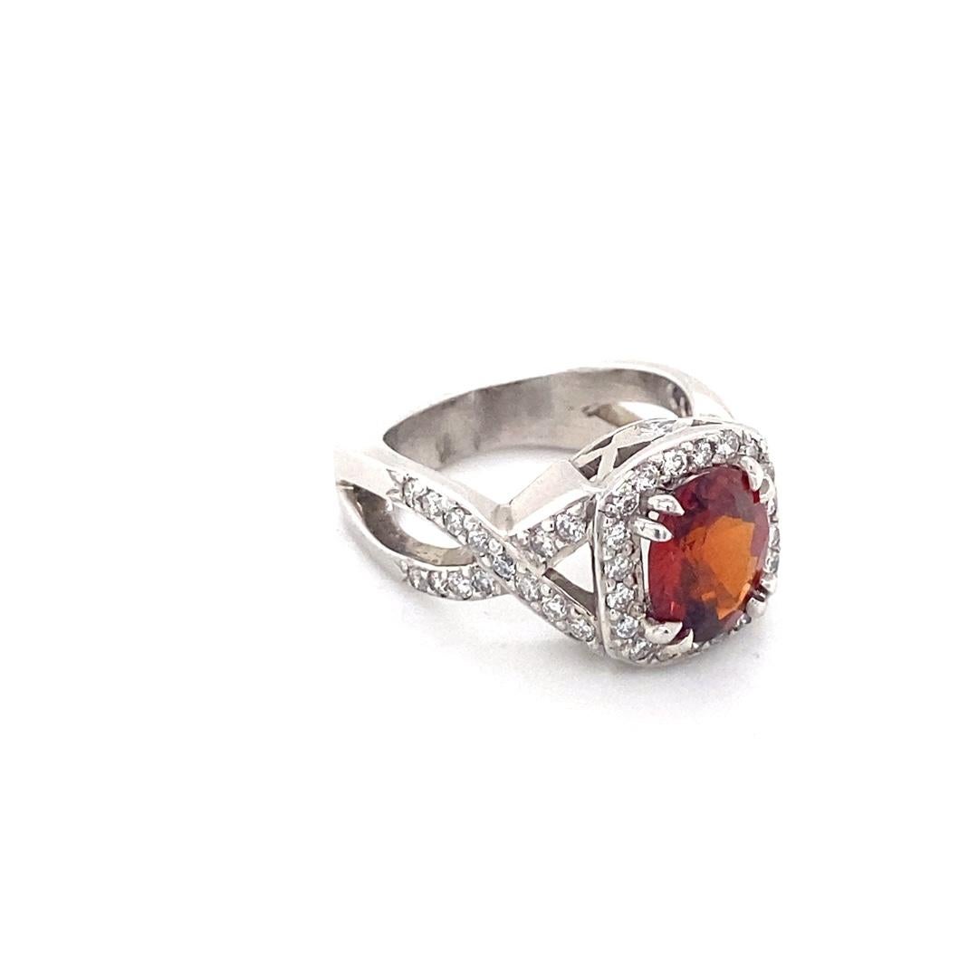 This ring features an absolutely stunning 2.40 carat oval garnet. This ring was handmade by our expert jewelers for this beautiful stone. The custom mounting has a diamond halo and crossover band with a total diamond weight of 0.75cttw. This one of