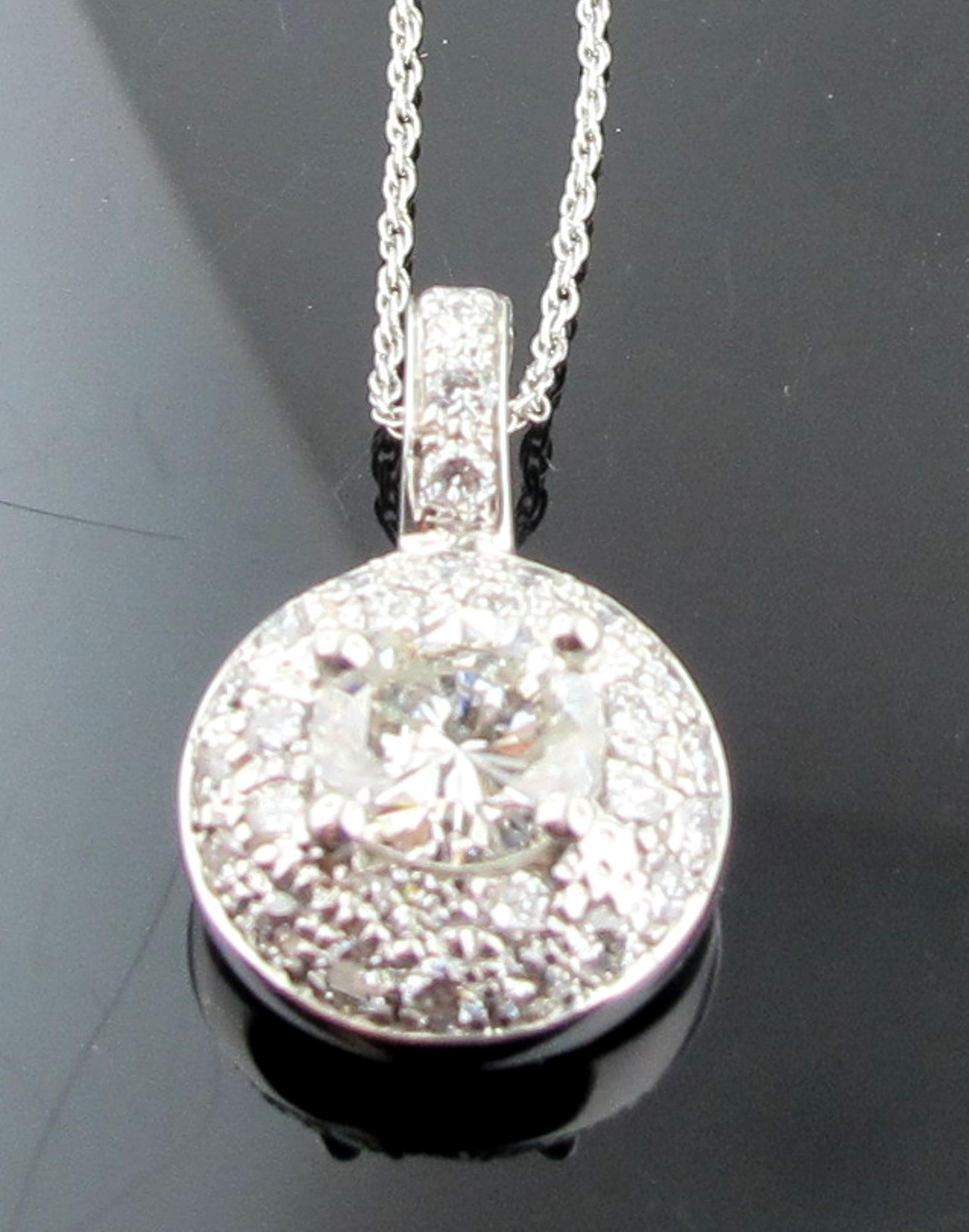 Serti dans de l'or blanc 14 carats, un diamant central rond de taille brillant pesant 1,16 carats, couleur J, pureté SI-1.  Sont également inclus 44 diamants ronds de taille brillant d'un poids total de 1,25 carat, pour un poids total de diamants de