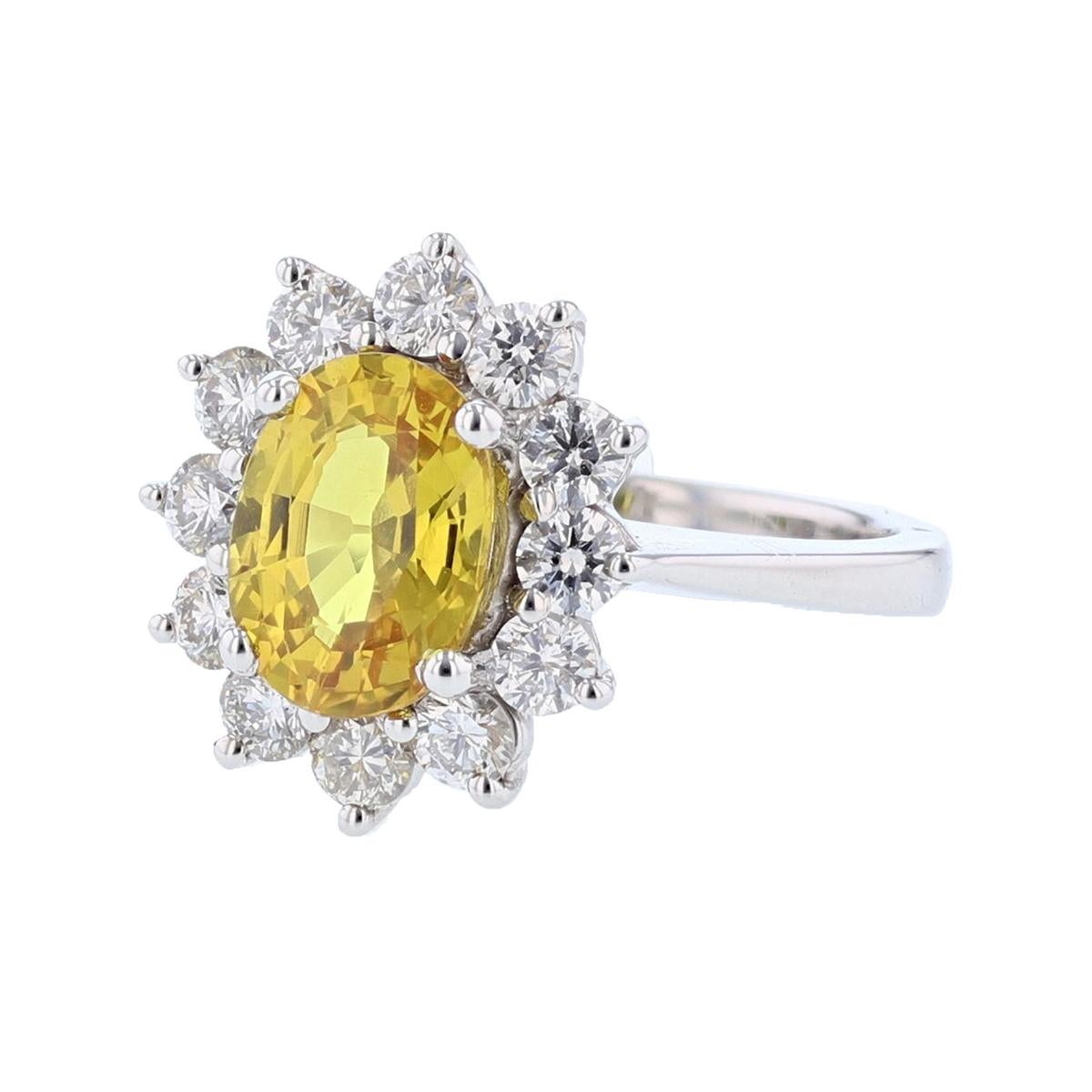 This ring is set in 14 karat white gold. The center stone is a Oval Yellow Sapphire weighing 2.49 carats and is prong set. The mounting features 12 round cut , prong set diamonds weighing 0.88cts.