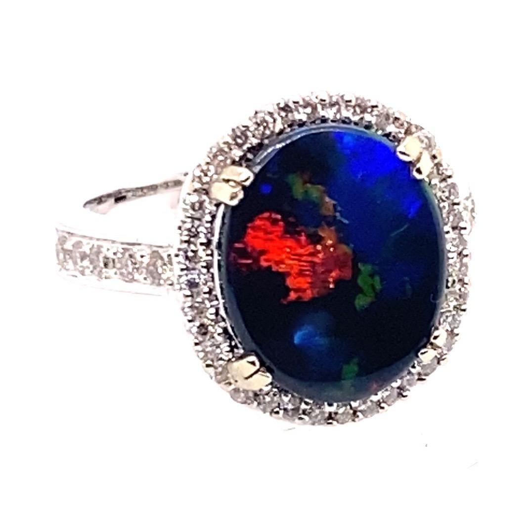 14 Karat White Gold 2.60 carat Australian Black Opal Diamond Cluster Ring

Center stone is a solid oval cabochon Australian black opal set in a four claw setting.  Surrounding the opal is 36 round brilliant cut diamonds in bead setting forming a