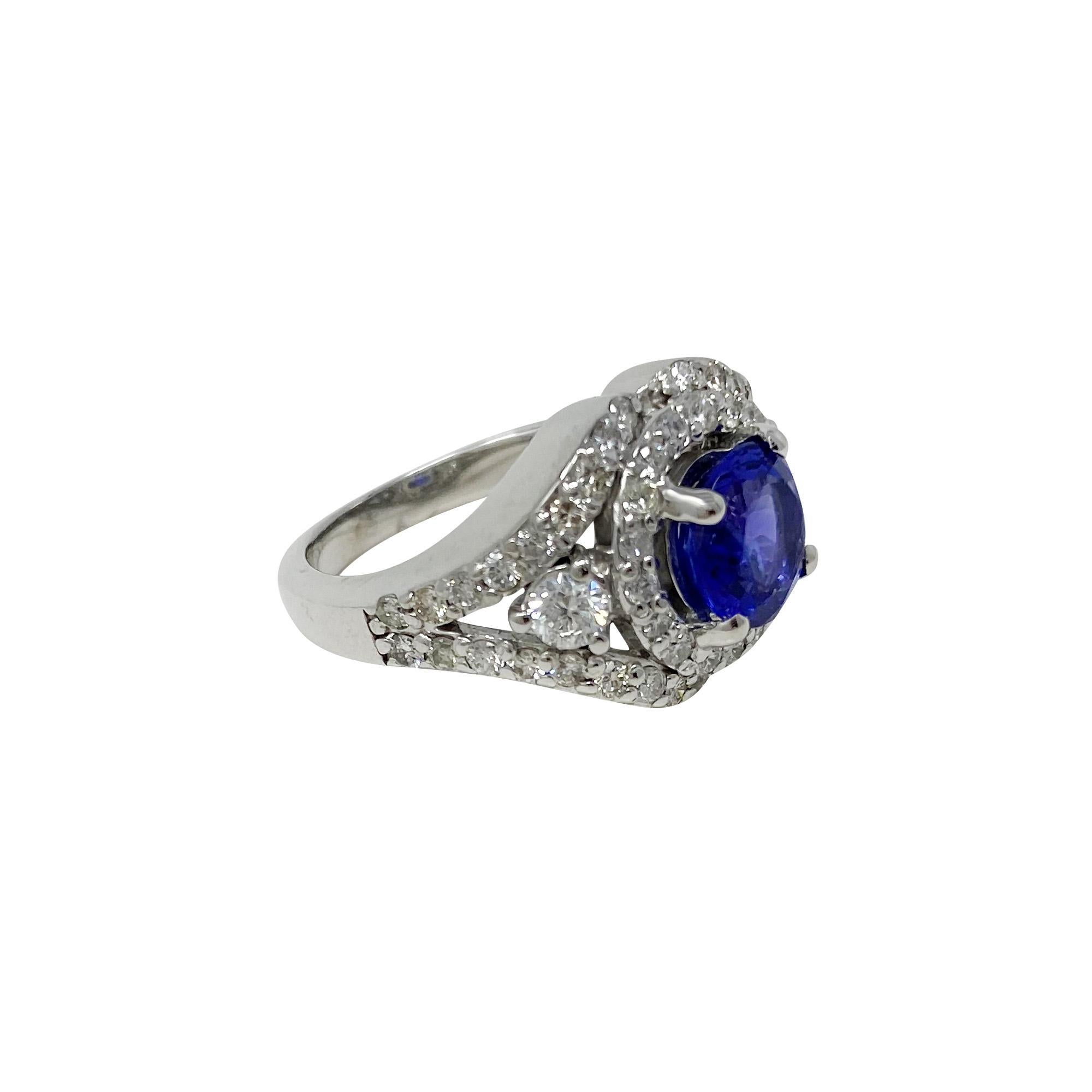 Weighing 2.63 carats, this beauty is surrounded by 0.70 cts of diamonds.  This stone is accompanied by G S, 2012 laboratory report stating:
Natural tanzanite
Round, faceted
2.63 cts
7.98 mm x 7.89 mm x 5.43 mm
Tone:  Dark
Intensity:  Strong
Hue: 