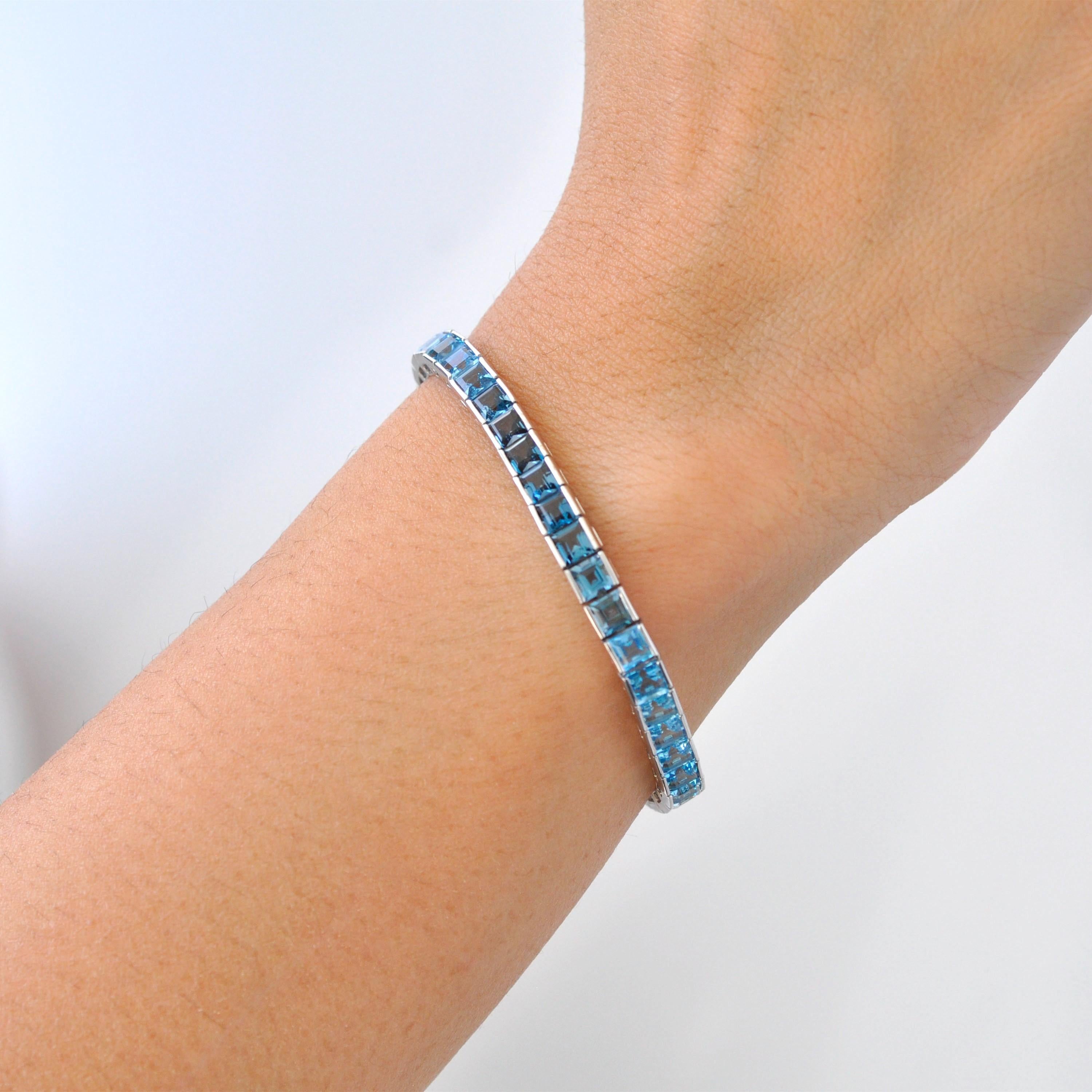 This exquisite 14K White Gold Blue Topaz Tennis Line Bracelet is a breathtaking display of elegance, sophistication, and timeless beauty. Featuring a seamless row of 4mm square-cut blue topaz gemstones, this bracelet showcases a captivating gradient