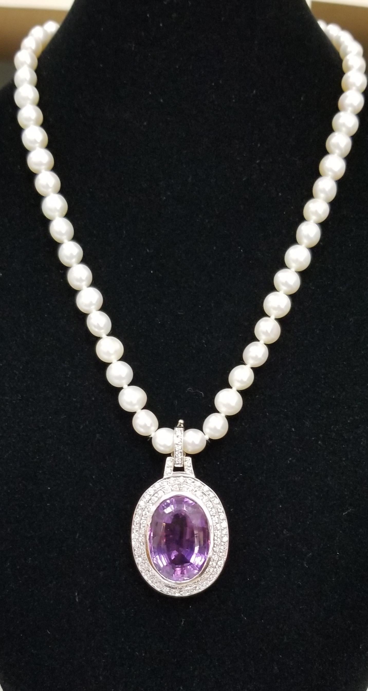 14k white gold amethyst and diamond pendant, containing 1 oval cut amethyst weighing 22.75cts. surrounded by 2 rows of 82 round full cut diamonds weighing 1.10cts. The piece is detachable on a 16 inch 7mm fresh water pearls. 