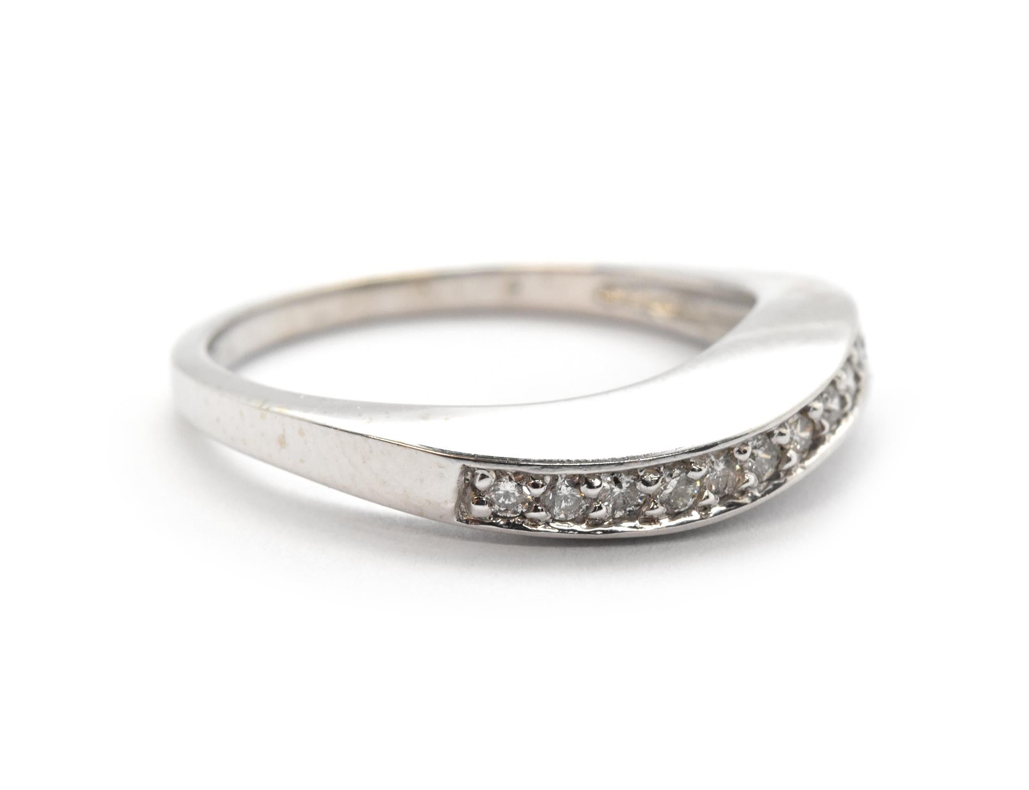 This ring is made in 14k white gold. It features round diamond set into a 