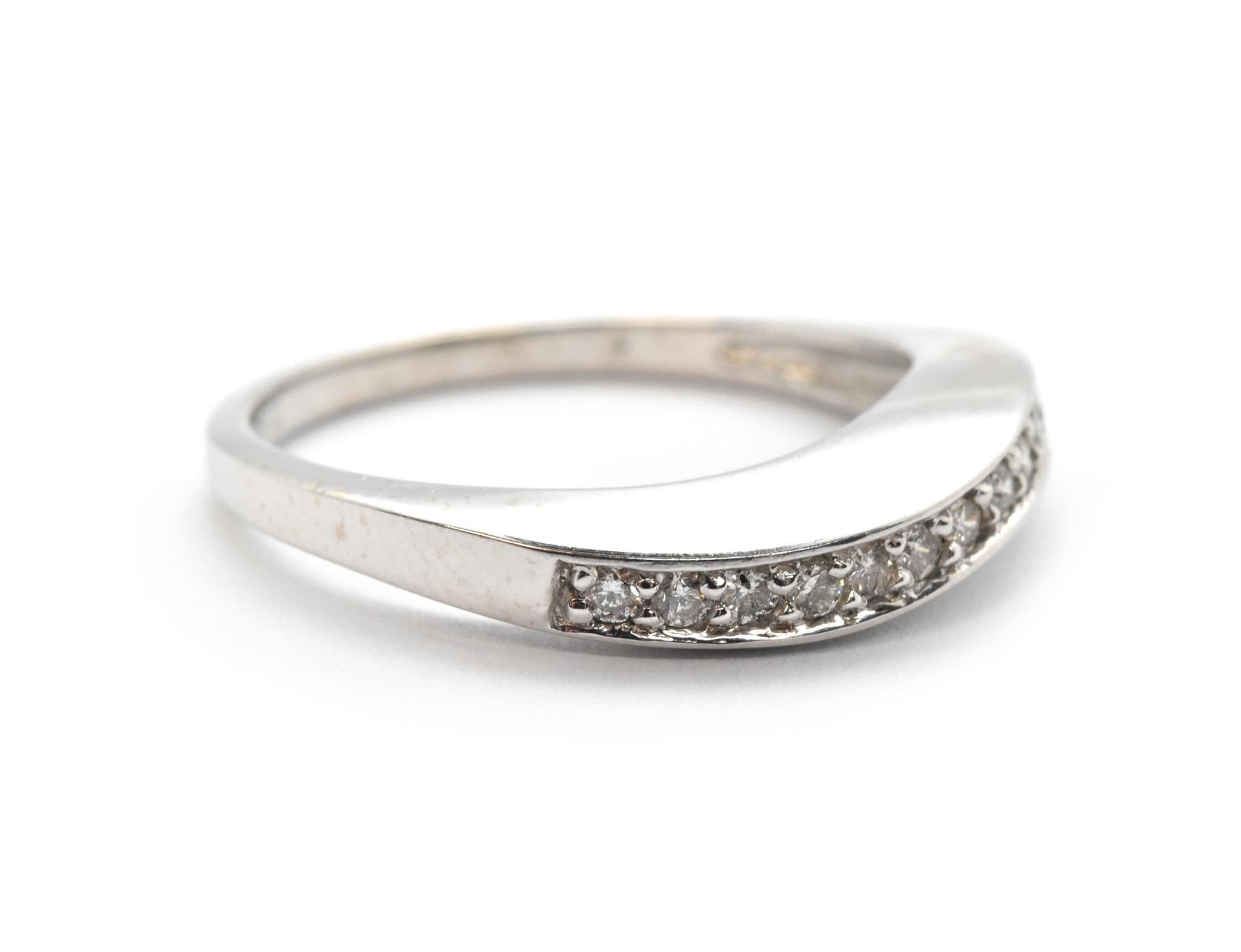 Questo anello è realizzato in oro bianco 14k. Presenta un diamante rotondo incastonato in un motivo a 