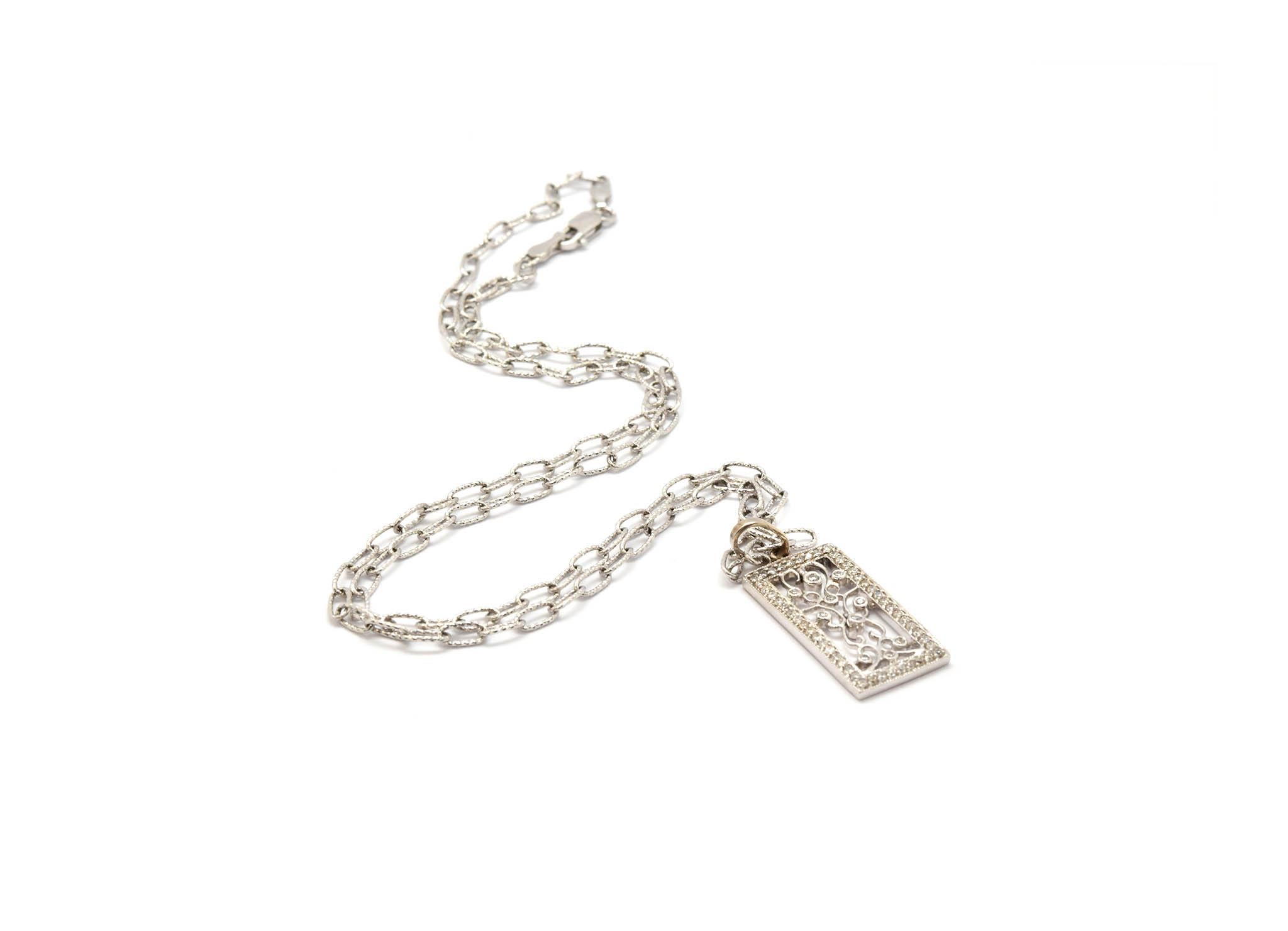 Ce charmant pendentif vintage en diamant est fabriqué en or blanc 14k. Le pendentif est monté sur un collier ovale de 18 pouces en or blanc 14k. Le pendentif est serti de diamants ronds pesant 0,60 carats. Le pendentif mesure 21,58 mm x 11,33 mm et