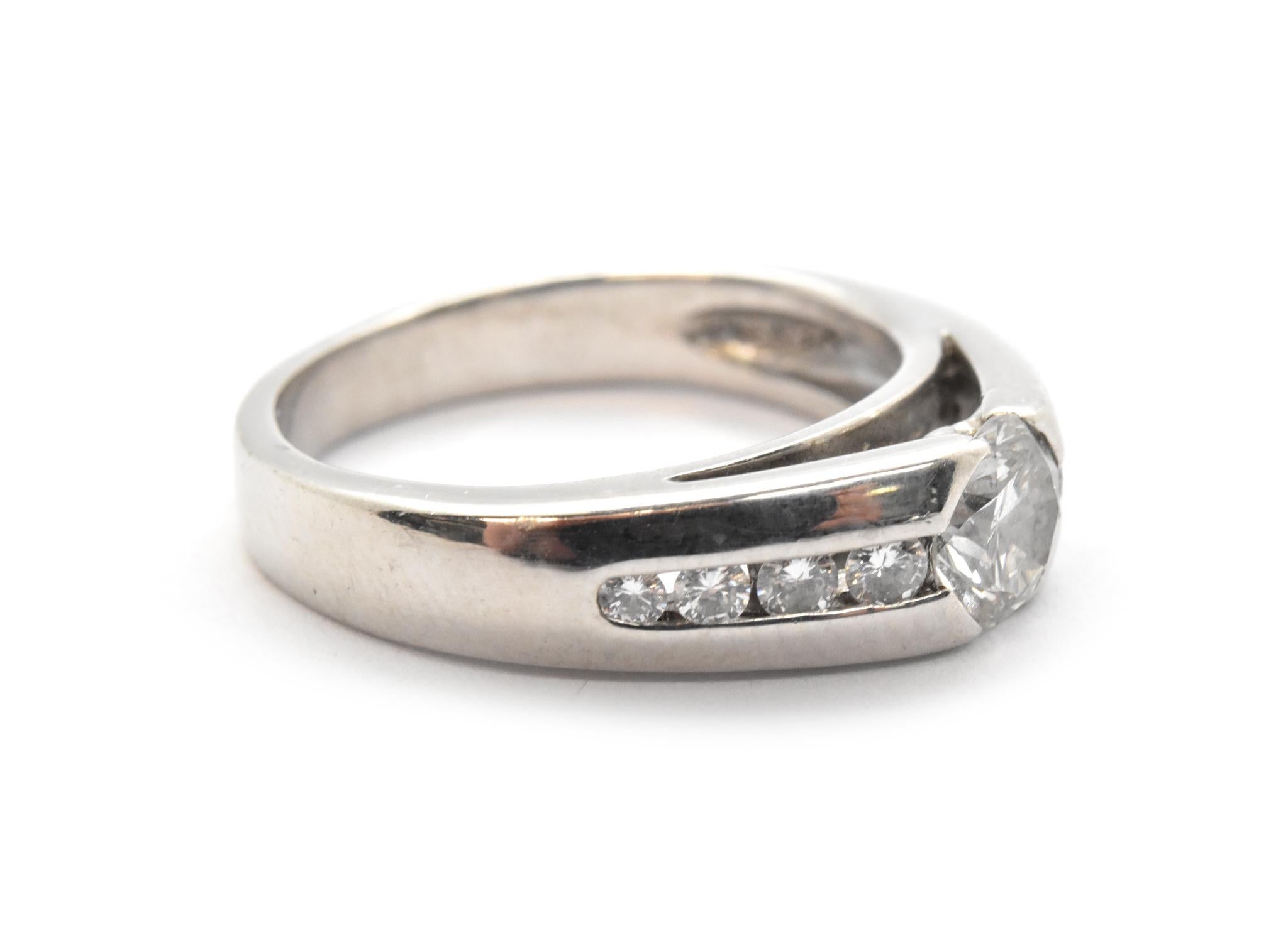 This sweet ring is made in 14k white gold. It features a larger round diamond at its center which is accented by smaller round diamonds. The diamonds have a total weight of 0.74ct, and they are graded G-H in color and VS-SI in clarity. The band