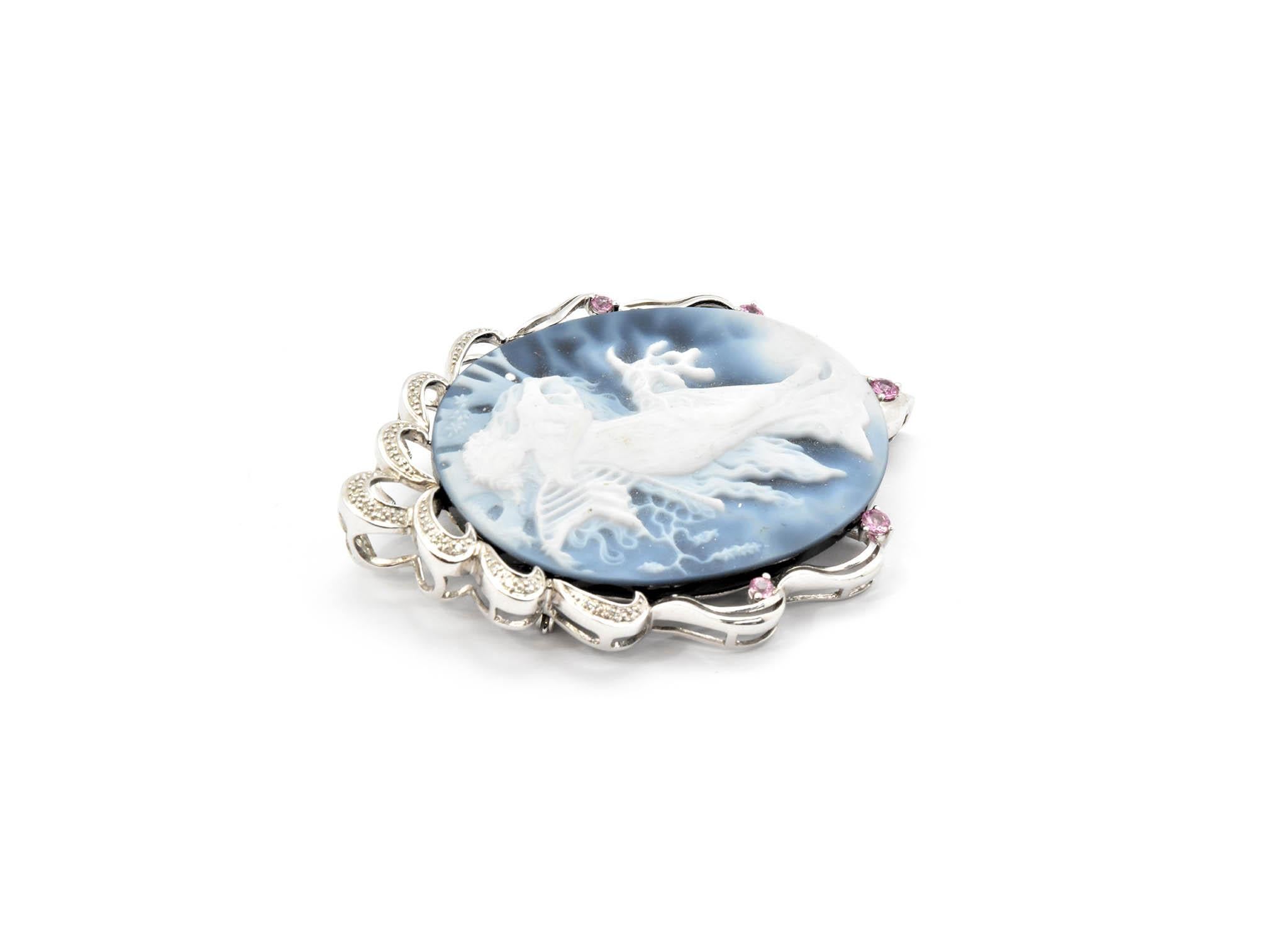 This 14k white gold and blue cameo brooch is simply unique! The brooch features a beautiful blue and white cameo set in 14k white gold. The pin has a beautiful 14k white gold bezel with diamonds and pink quartz stones. The brooch measures 50mm x