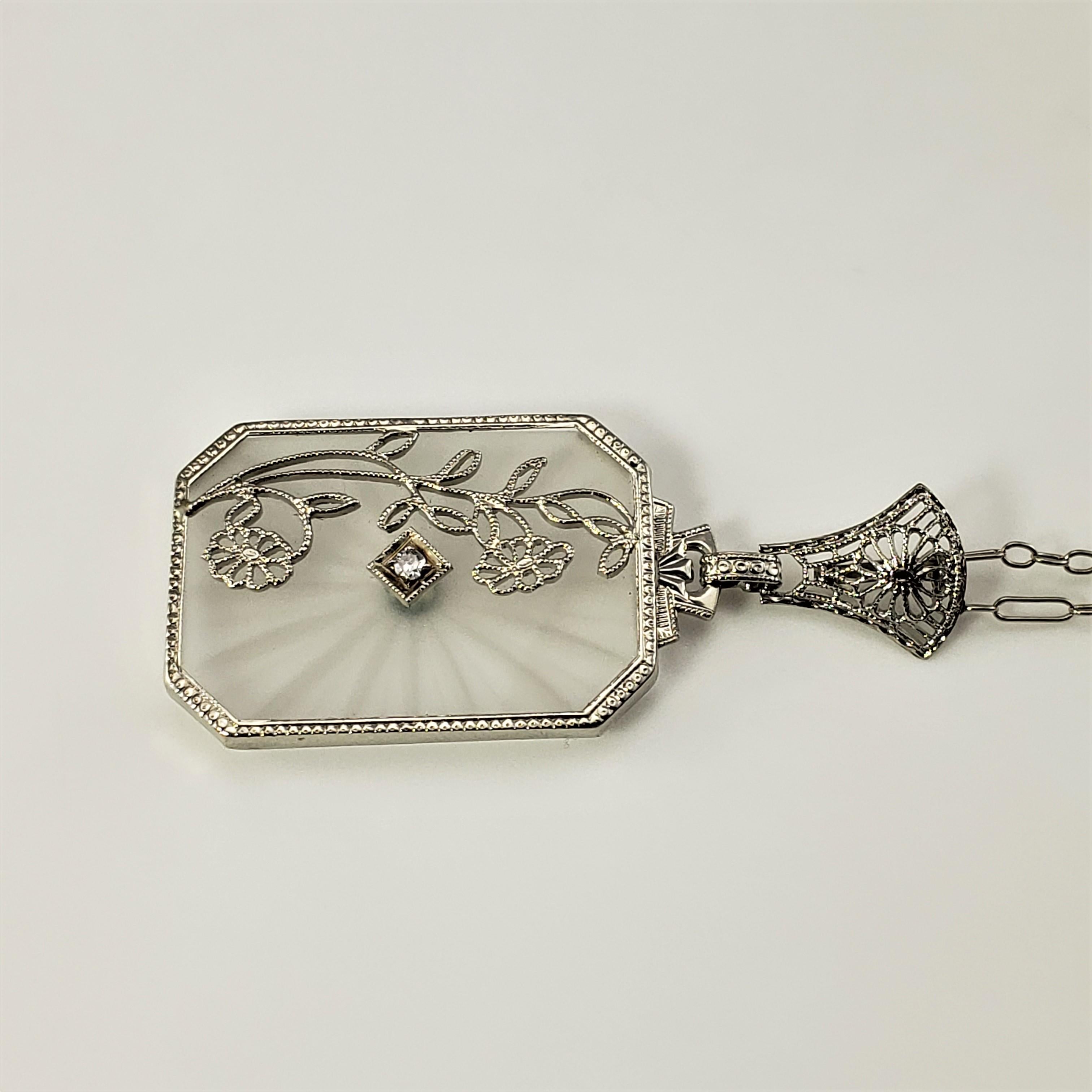 Art Deco 14 Karat White Gold and Camphor Glass Lavalier Pendant with Diamond Necklace-

This lovely 14K white gold filigree and camphor glass floral pendant features one round single cut diamond and suspends from an elegant white gold