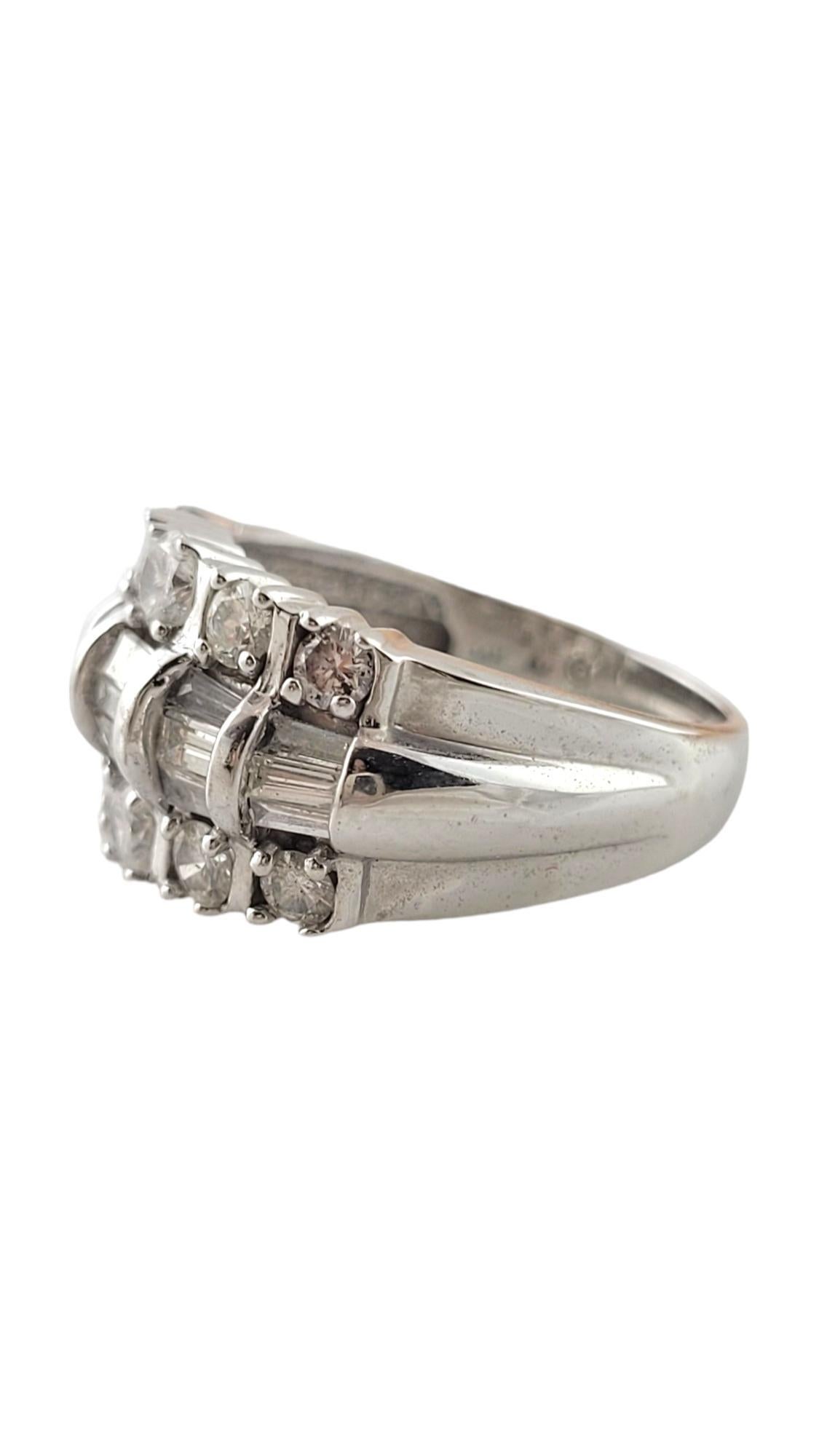 Vintage 14 Karat White Gold and Diamond Band Size 7-

This spectacular ring features 15 baguette diamonds (.45 ct. twt.) and ten round brilliant cut diamonds (.82 ct. twt.) set in beautifully detailed 14K white gold. Width: 12 mm. Shank: 3