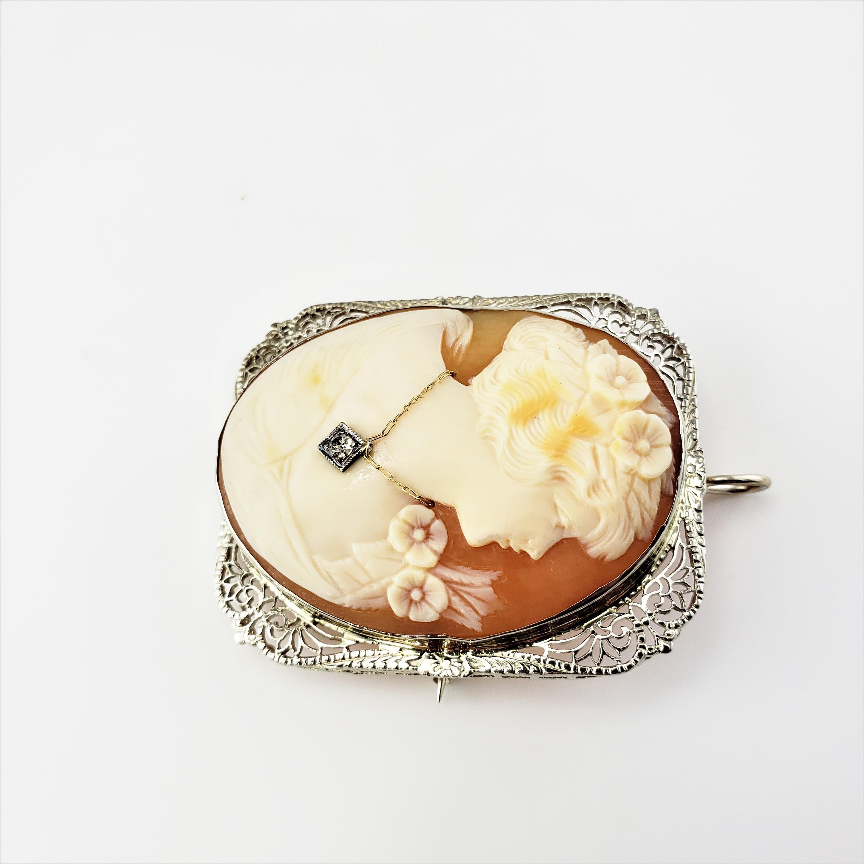 14 Karat White Gold Cameo Brooch Pendant-

This stunning cameo features a lovely lady in profile set in beautifully detailed 14K white gold filigree.  Accented with one round old mine cut diamonds.  Can be worn a brooch or a pendant.

Approximate