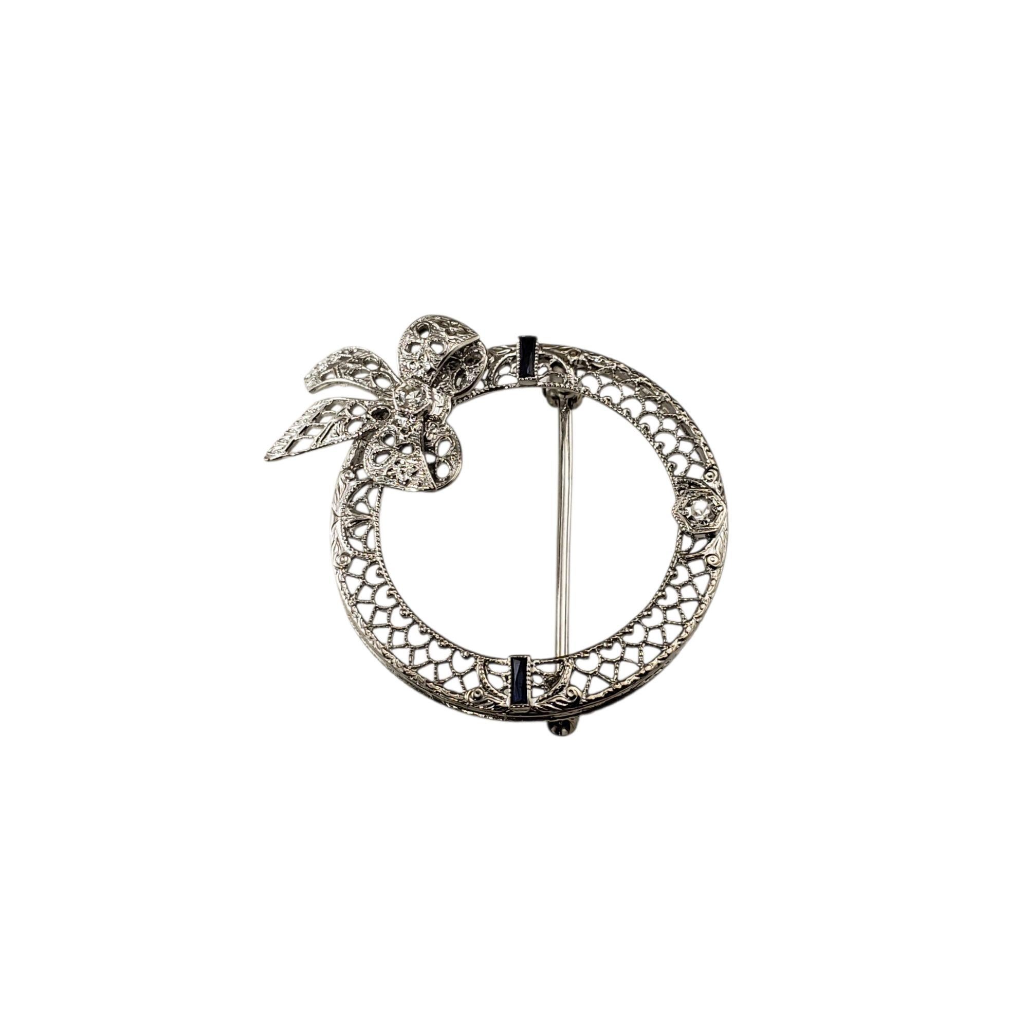 Spilla/spillone a cerchio in oro bianco 14 carati e diamanti.

Questa elegante spilla è finemente realizzata in oro bianco 14 carati e presenta un dettagliato disegno a filigrana aperta con un grazioso motivo a fiocco. La spilla è impreziosita da