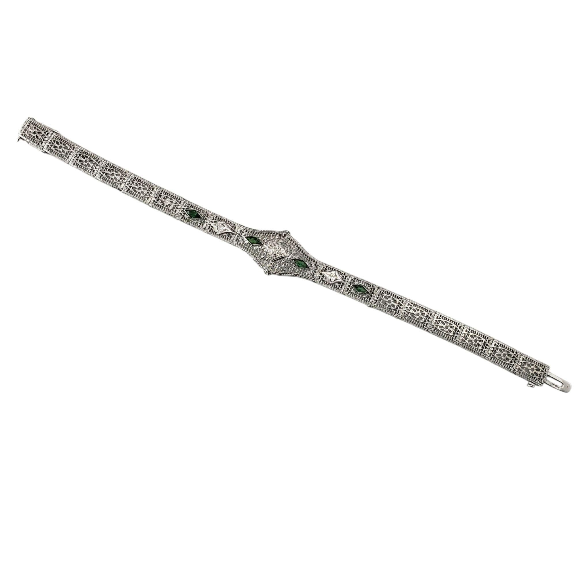 14 Karat White Gold and Diamond Filigree Bracelet-

This exquisite bracelet is crafted in 14K white gold and showcases intricate filigree detailing characteristic of the Art Deco era. At its center, a single sparkling diamond is flanked by two
